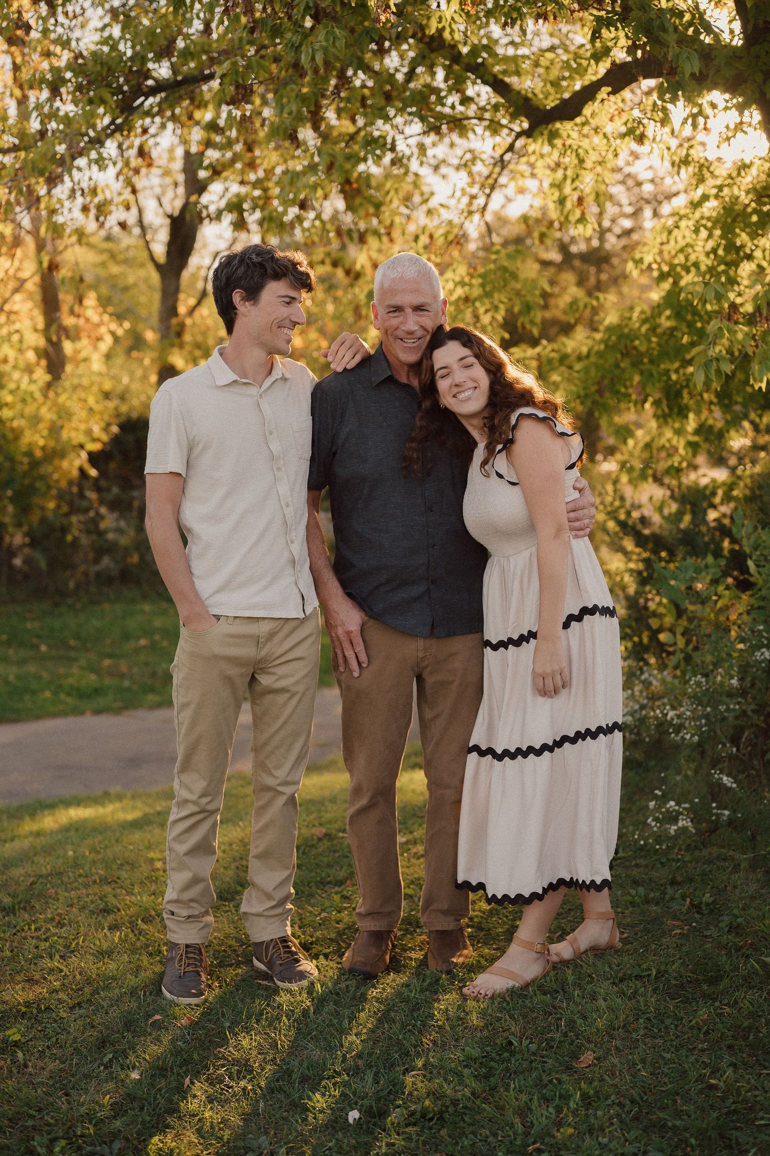 Group portrait session in a park during sunset with trees and golden light.