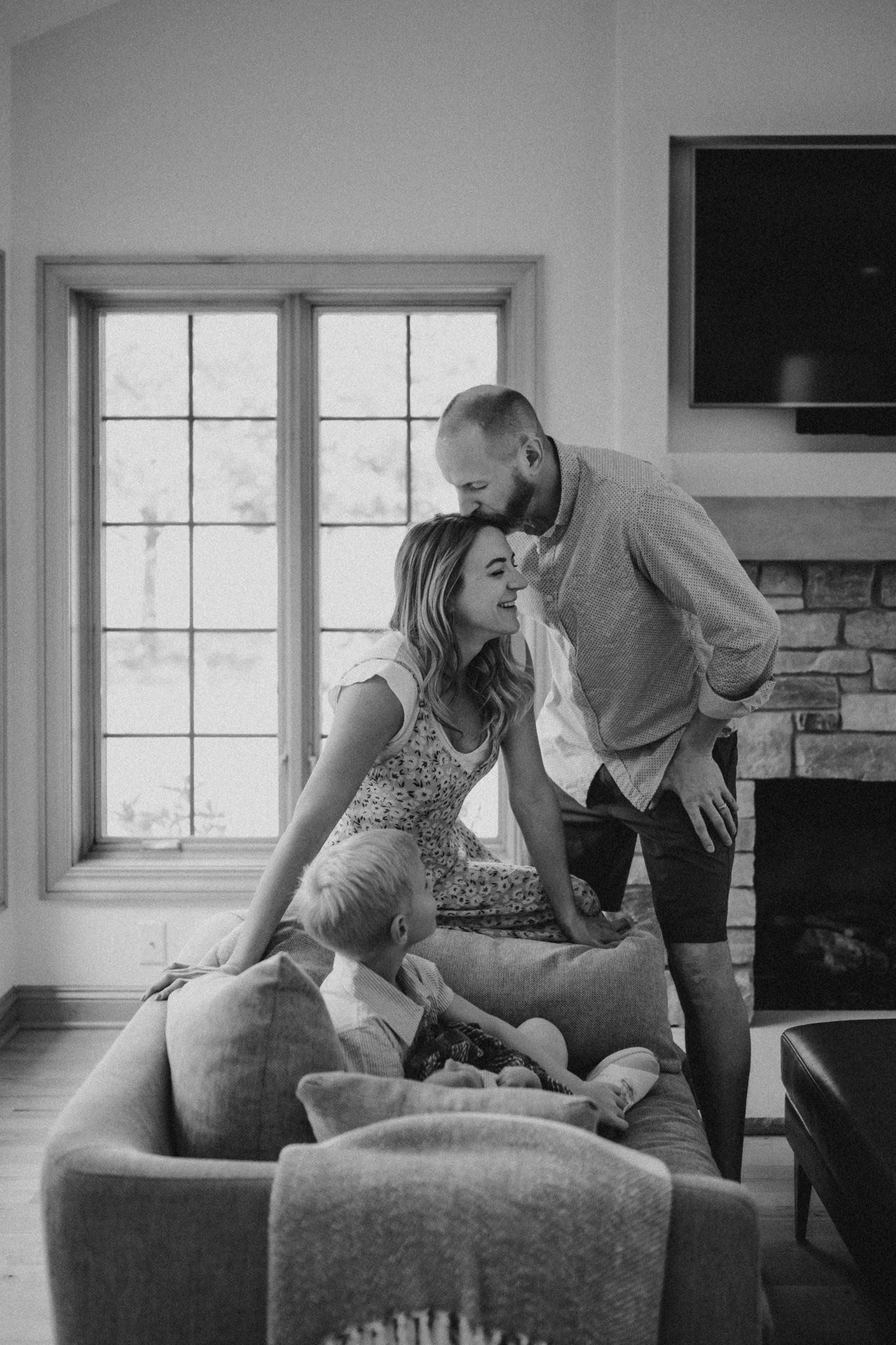 Black and white photo of intimate family moment in a modern living room.
