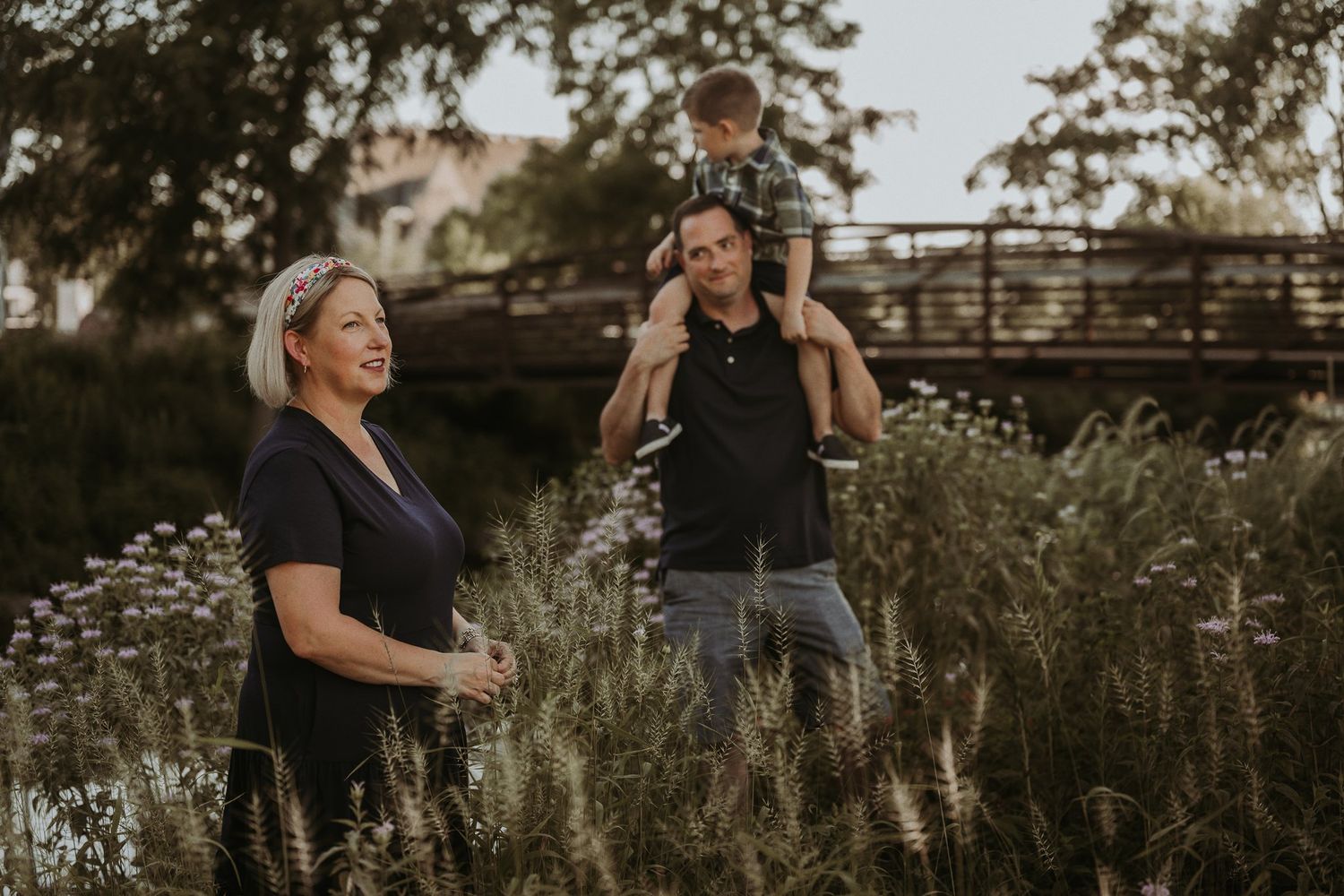 Candid family portrait with playful interactions in field of white flowers.