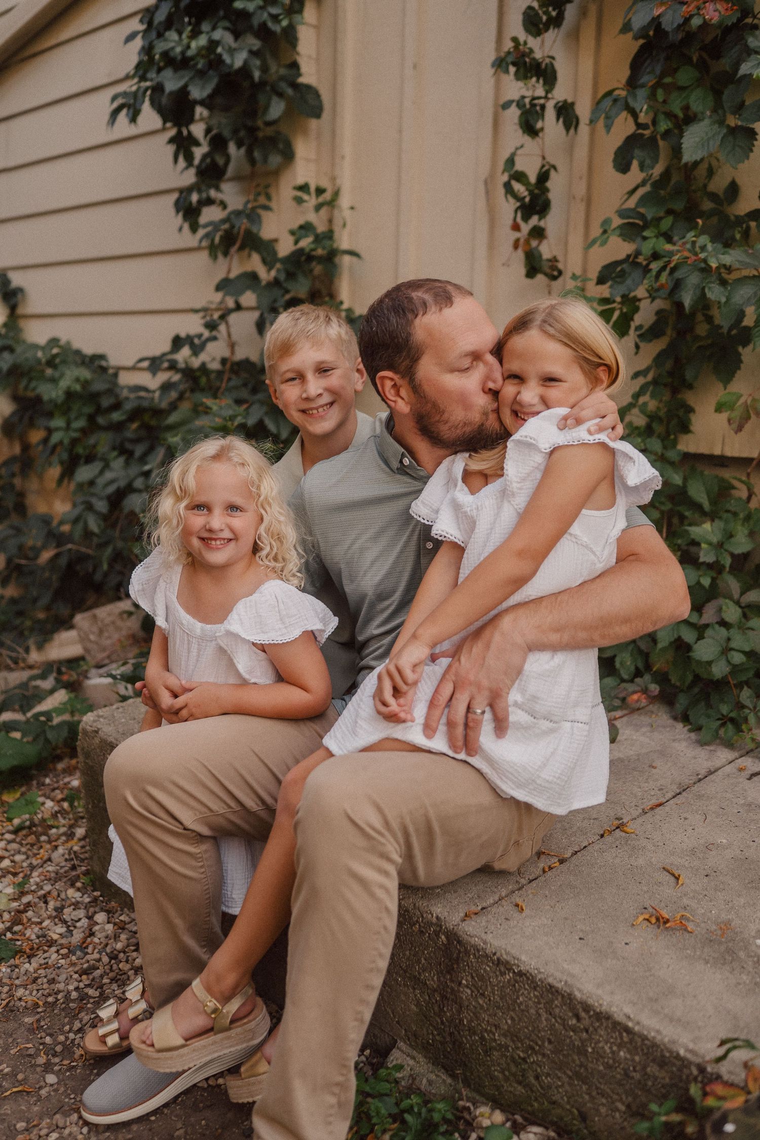 A tender family moment shared while sitting on concrete steps.