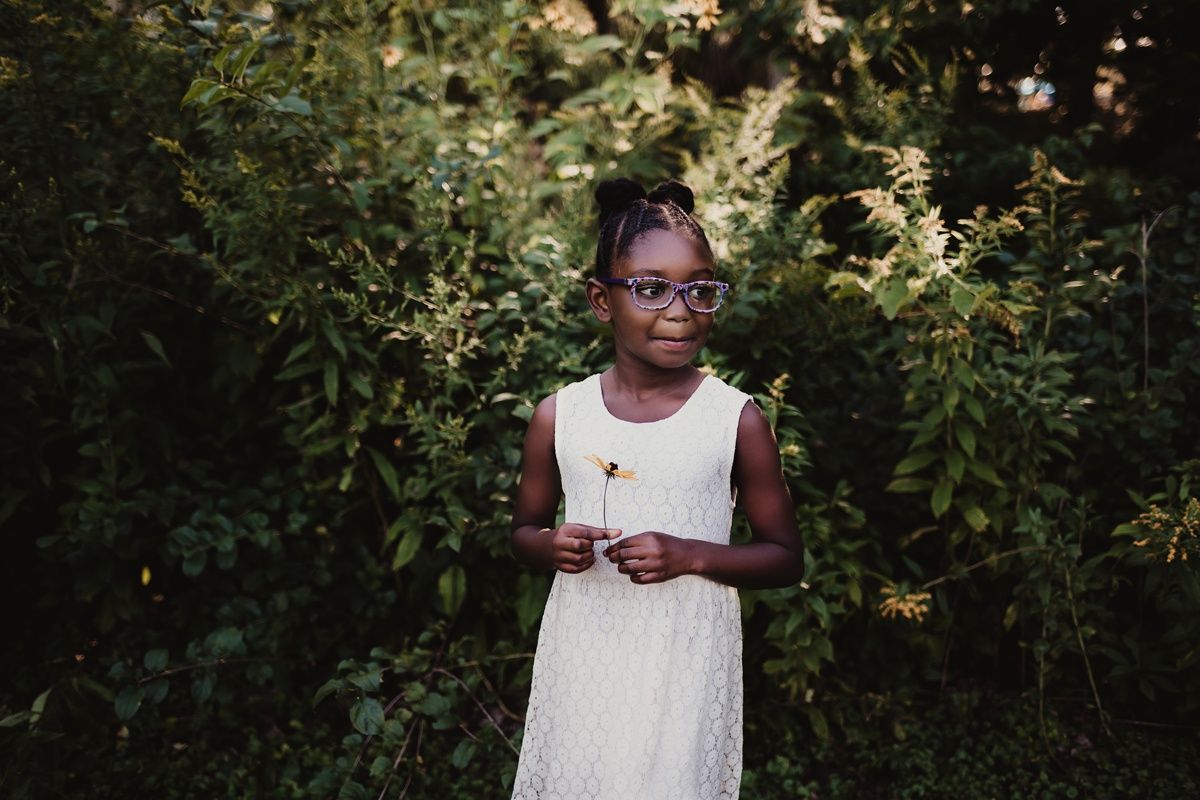 A contemplative moment captured in an outdoor garden setting with natural lighting.