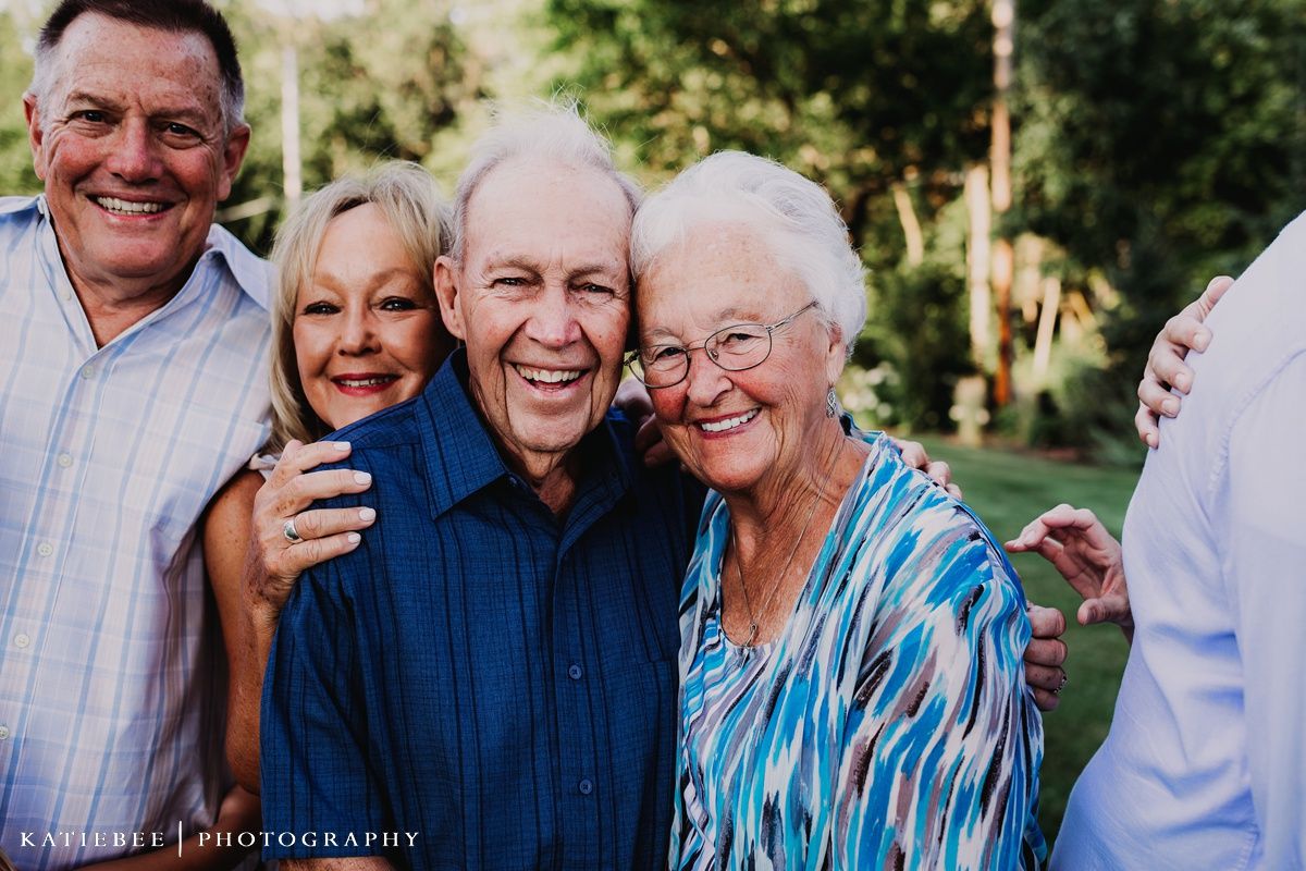 Close-up outdoor portrait of seniors and adults sharing a genuine moment together.