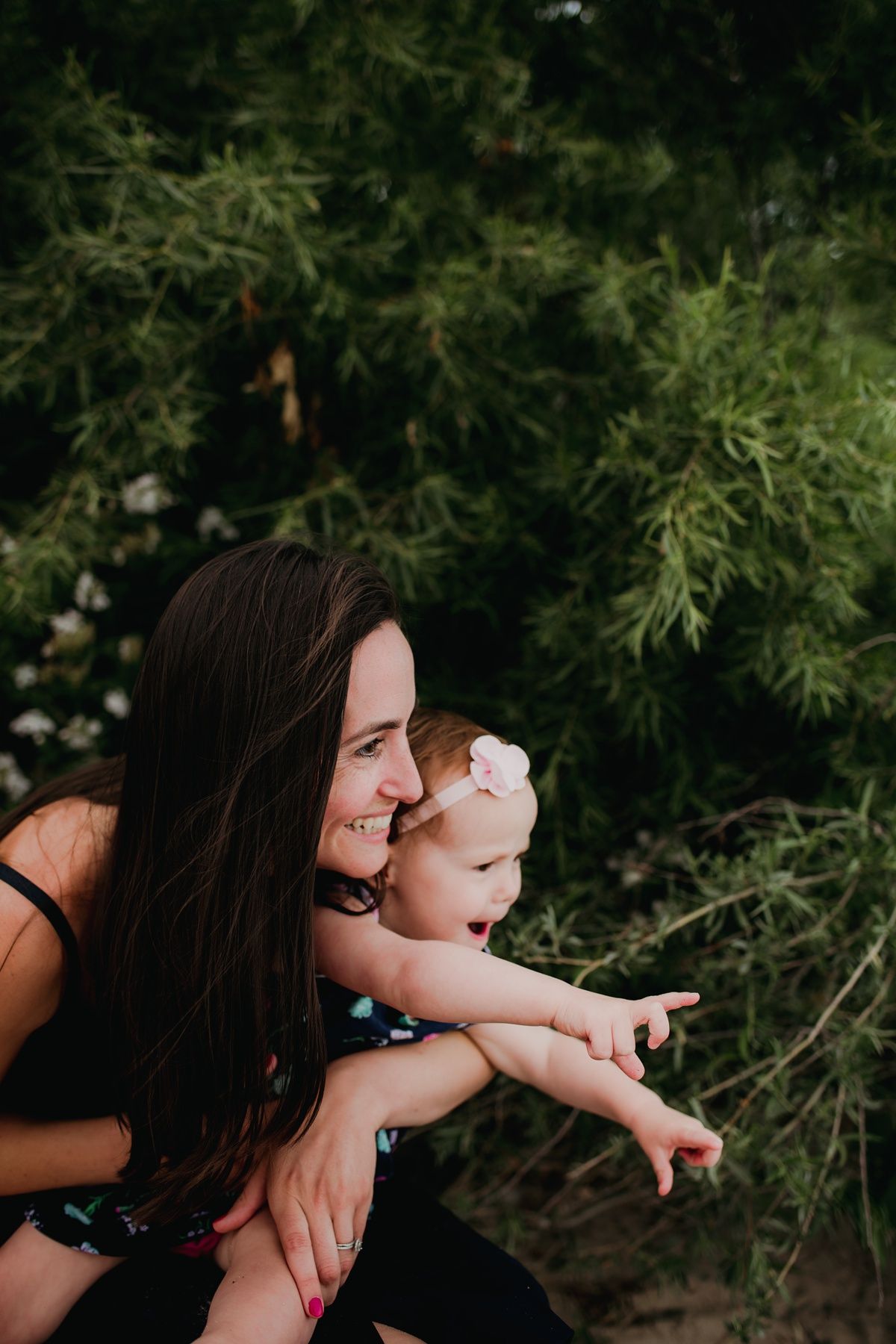 A joyful outdoor moment captured against lush greenery on a sunny day.