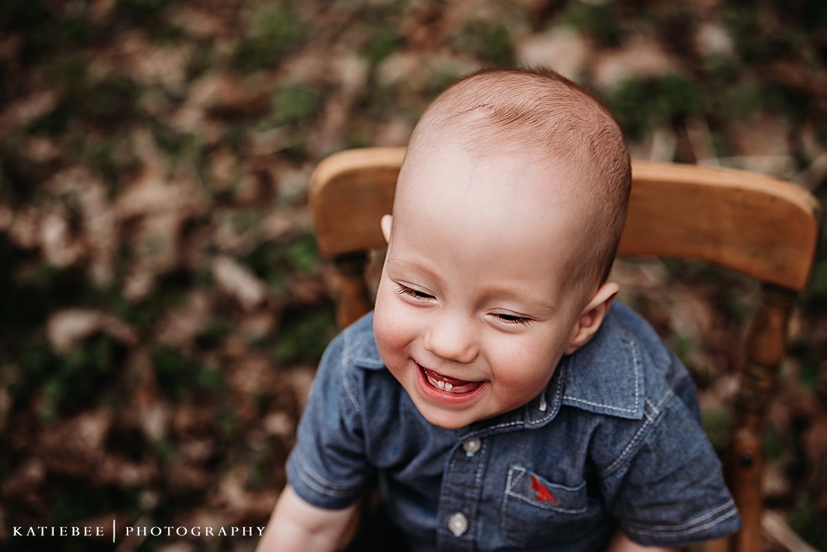Pure joy captured in portrait of small child sitting in wooden chair outdoors.