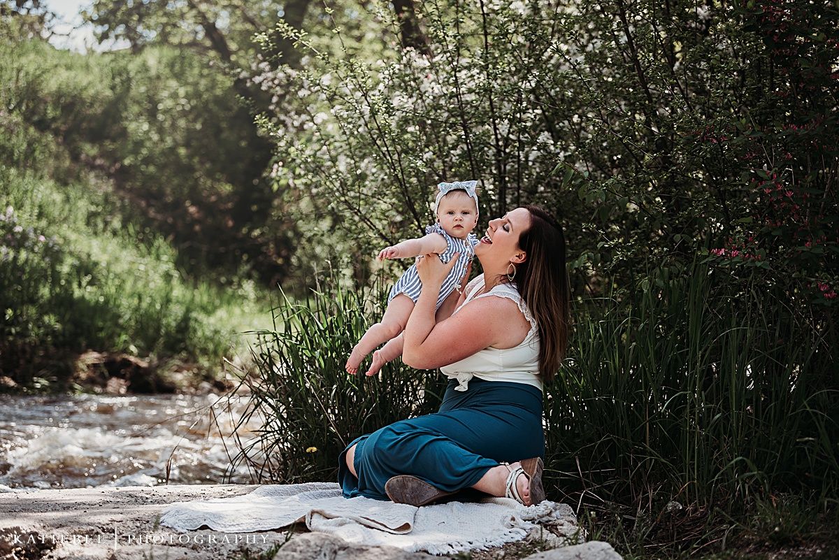 Joyful outdoor moment captured on rocks near flowering bushes and greenery.