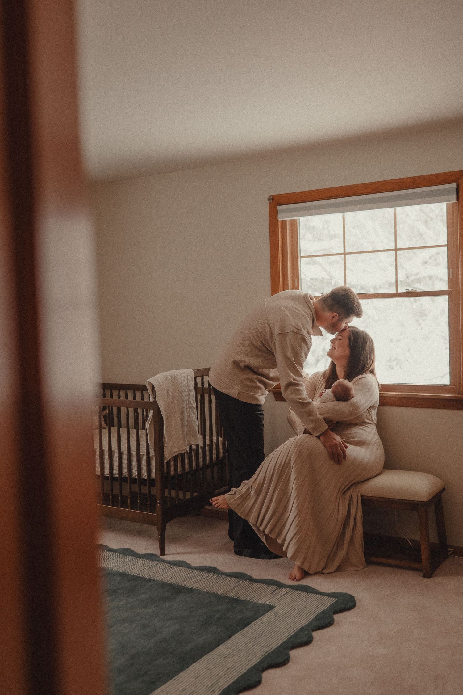 A tender moment captured in a sunlit room with soft window light.