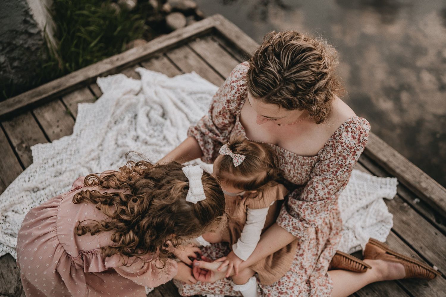 An intimate overhead view of a tender family moment on a wooden dock.