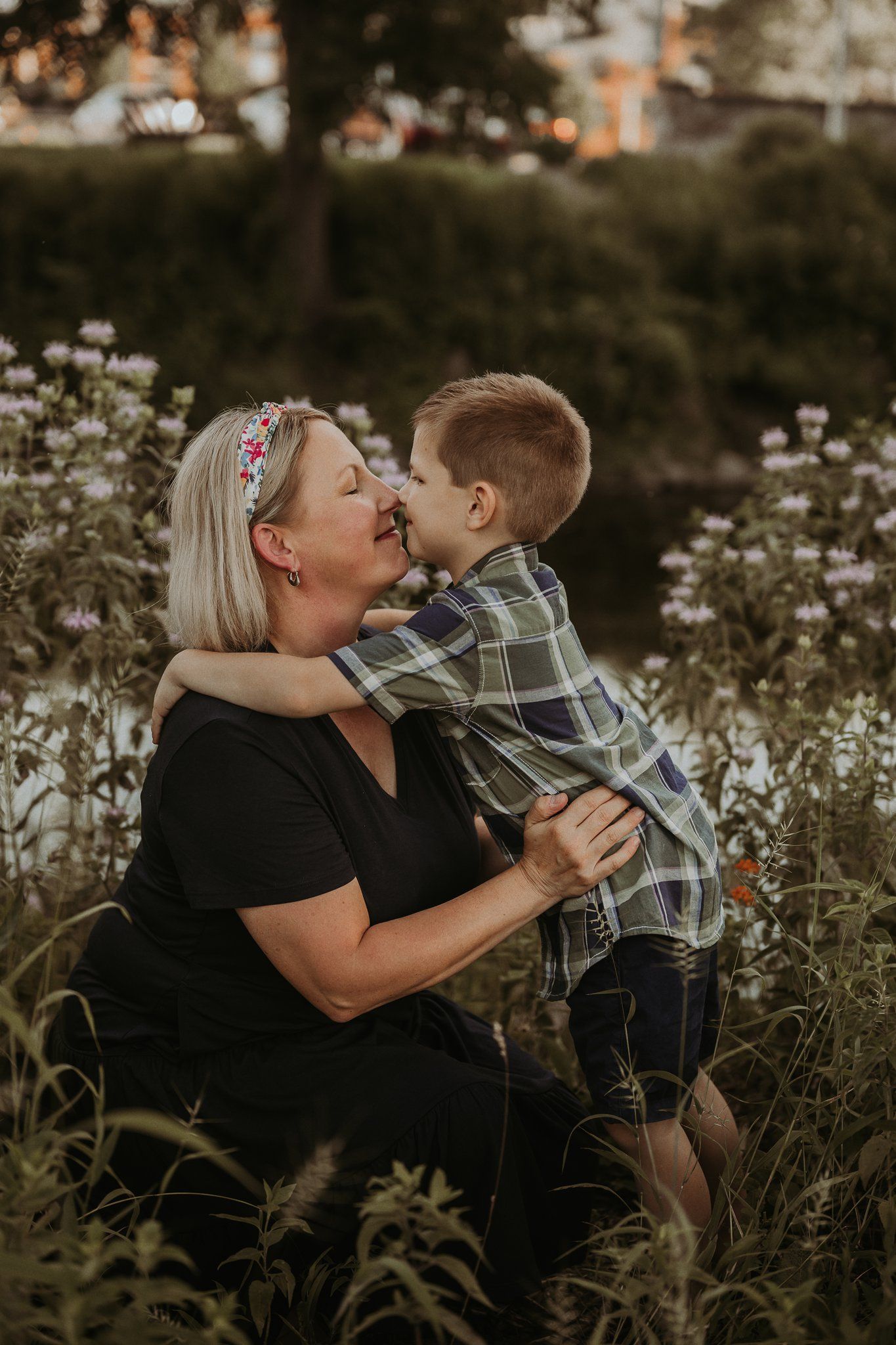 Loving embrace shared between parent and child surrounded by blooming wildflowers.