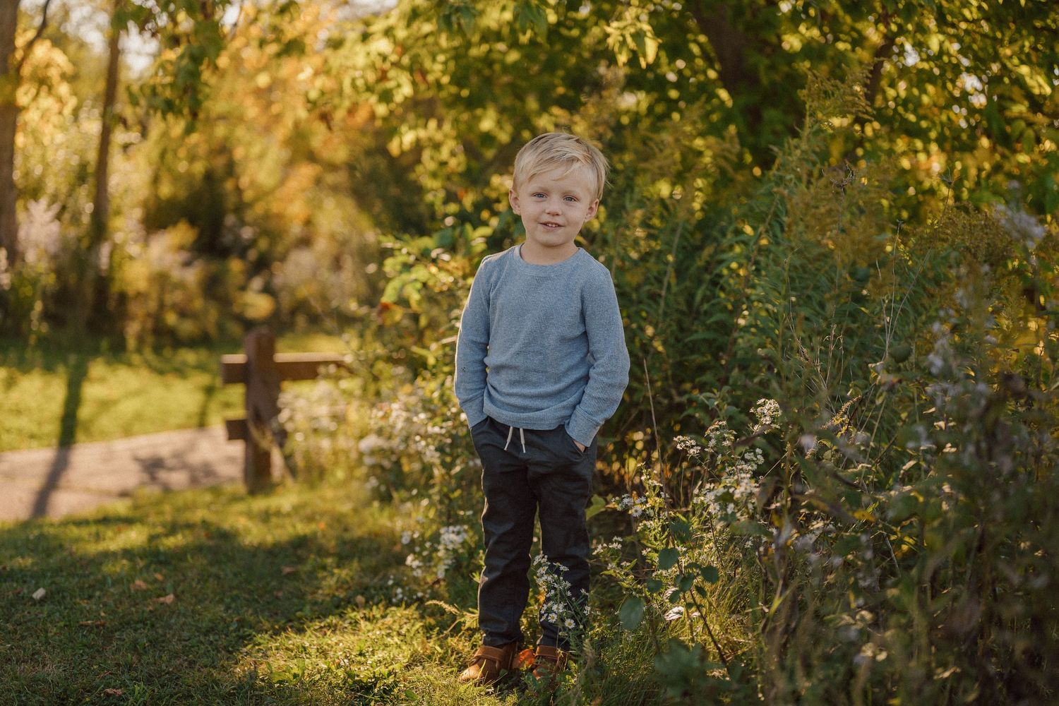 Children playing in a sunlit garden with autumn foliage in the background.