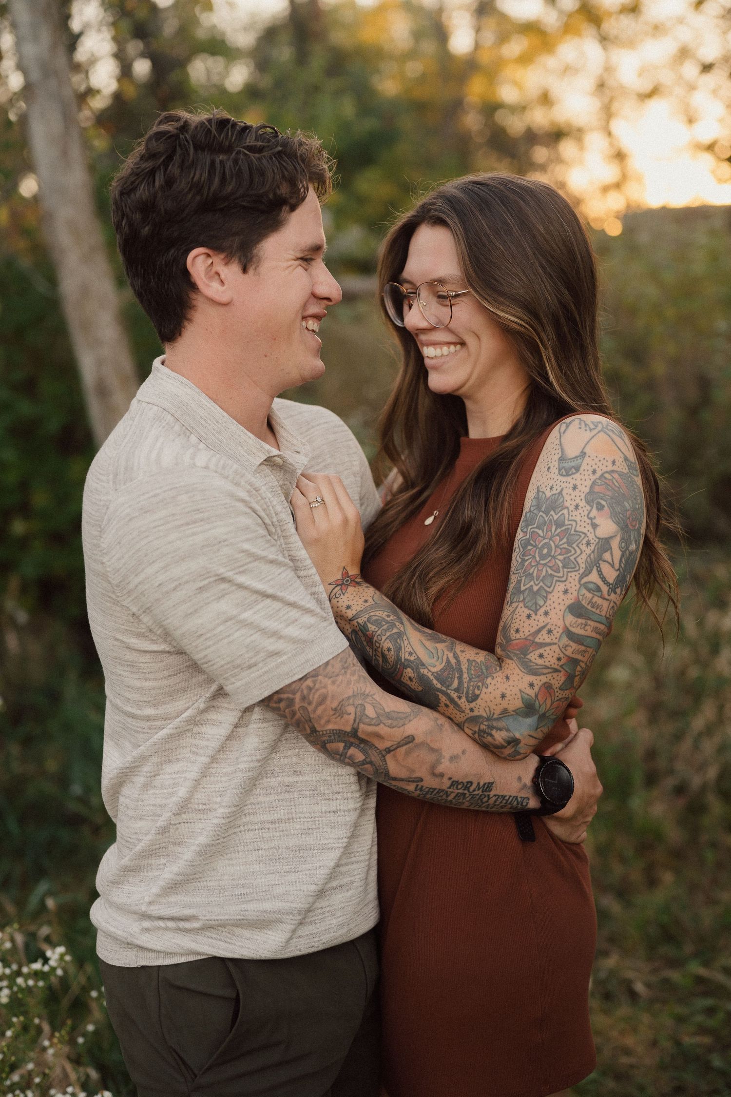 Couple sharing joyful laughter together during outdoor autumn photoshoot.