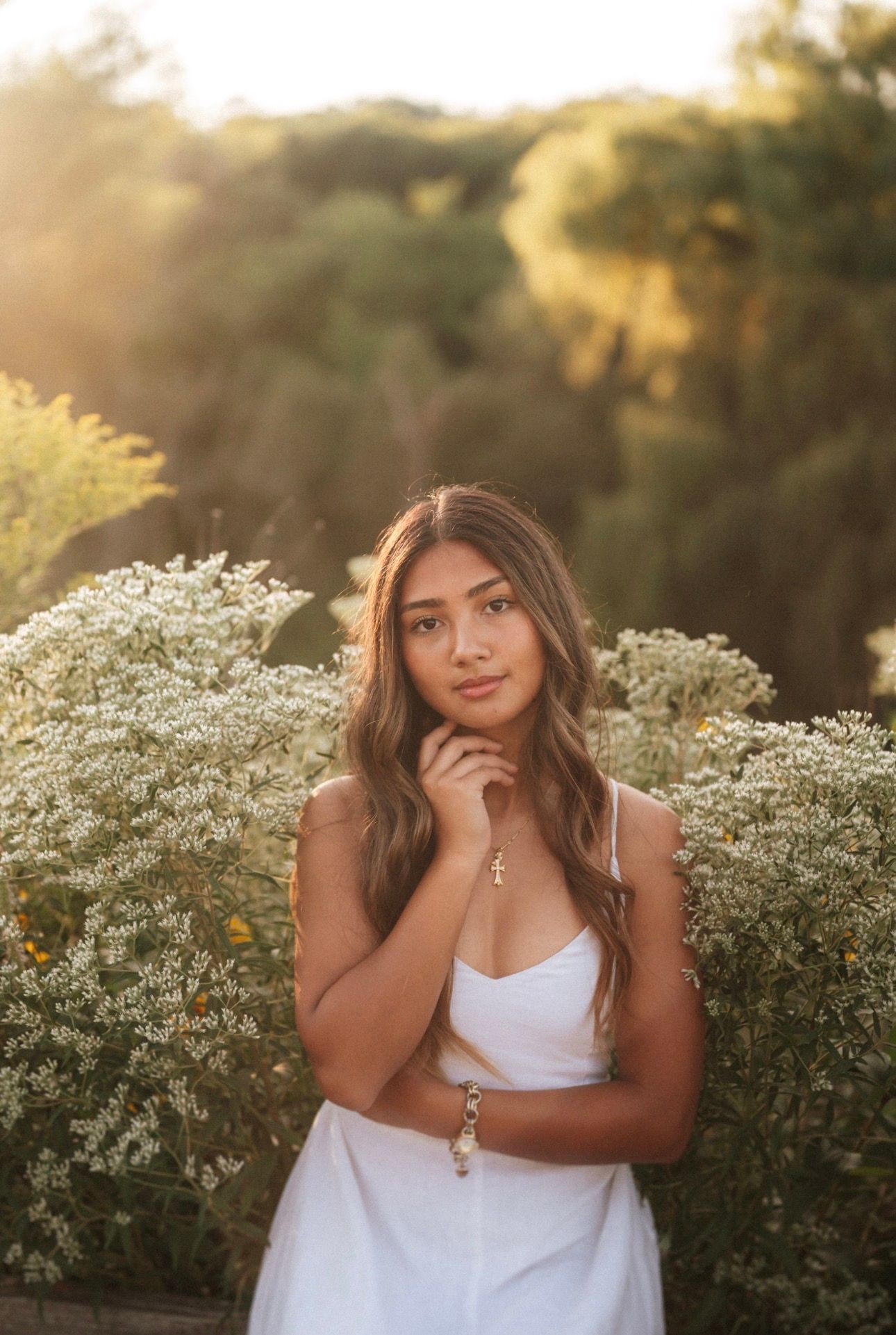 White dress portrait among delicate white flowers at golden hour.
