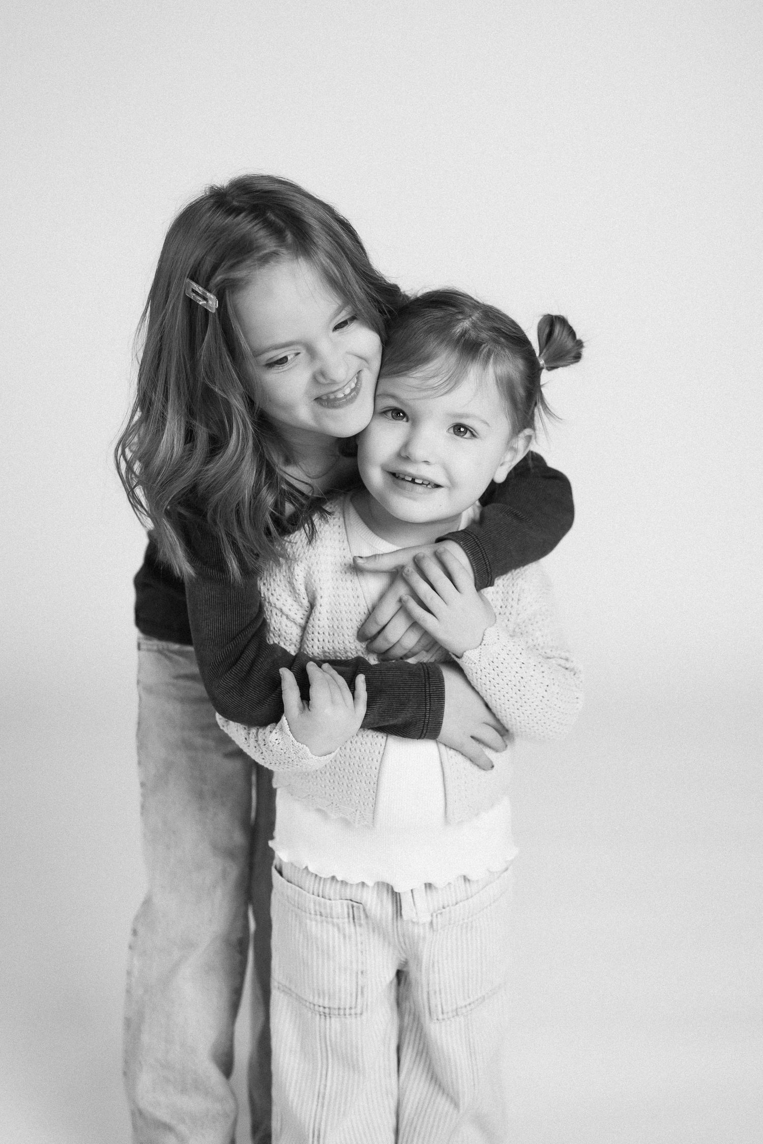 Black and white photo series showing playful embraces and interactions against a white background.