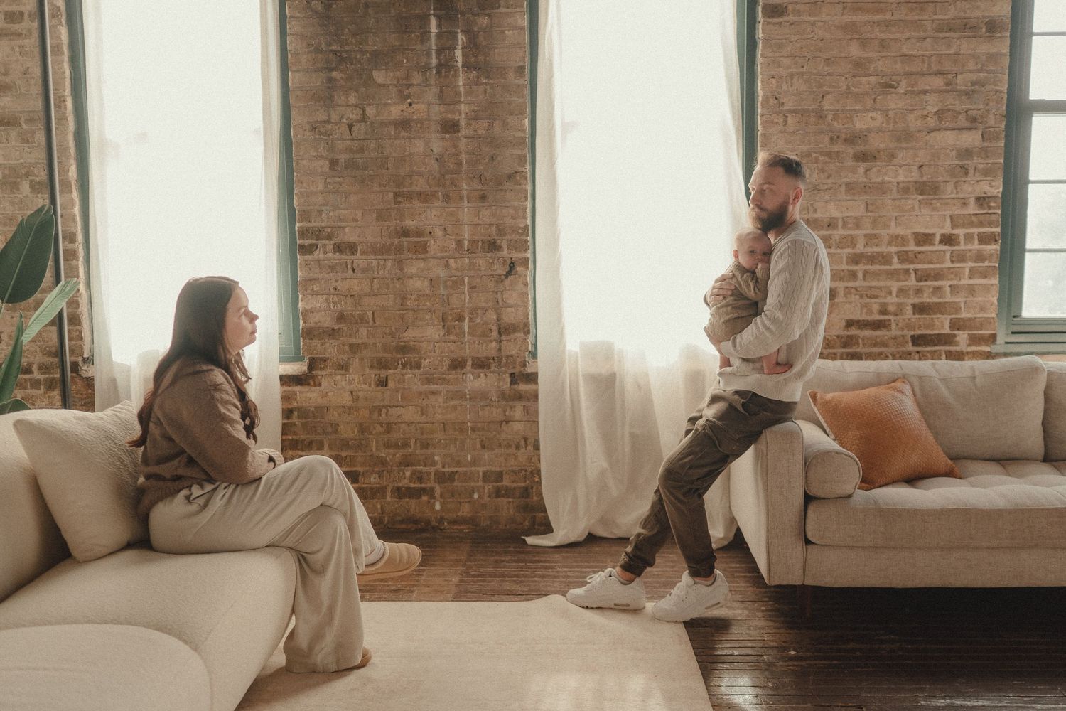 Lifestyle session in industrial space with exposed brick walls and natural window light.