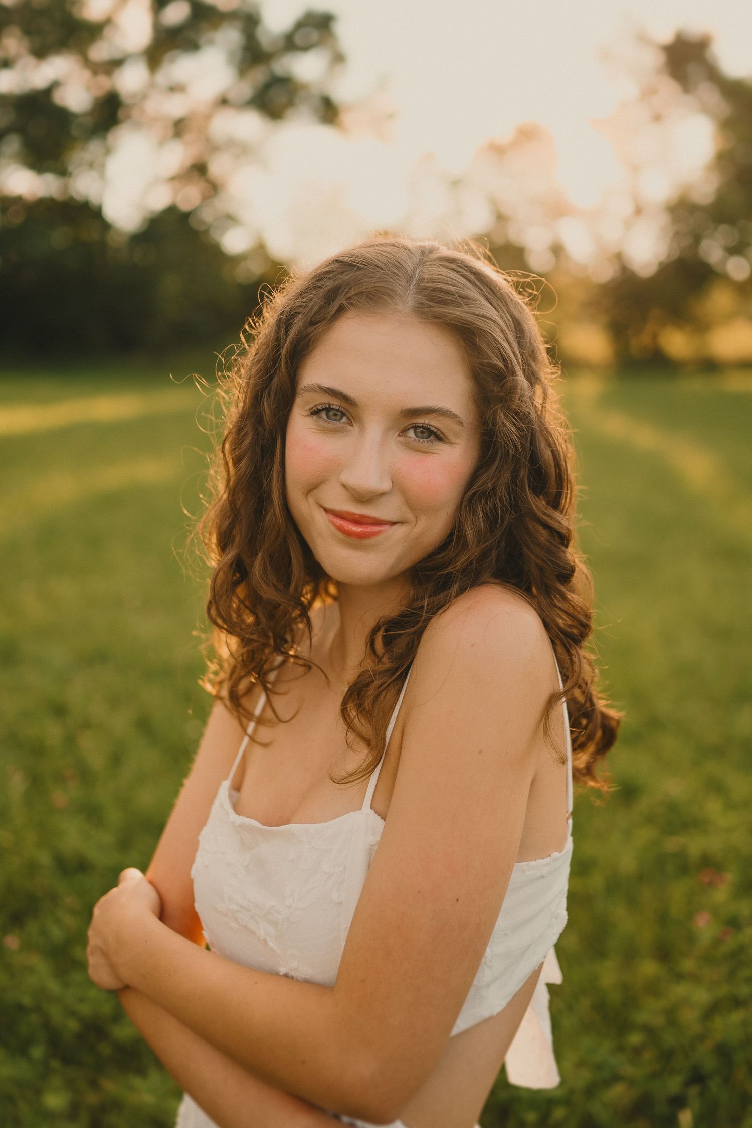 Warm sunset light creates a golden glow in this outdoor summer portrait.