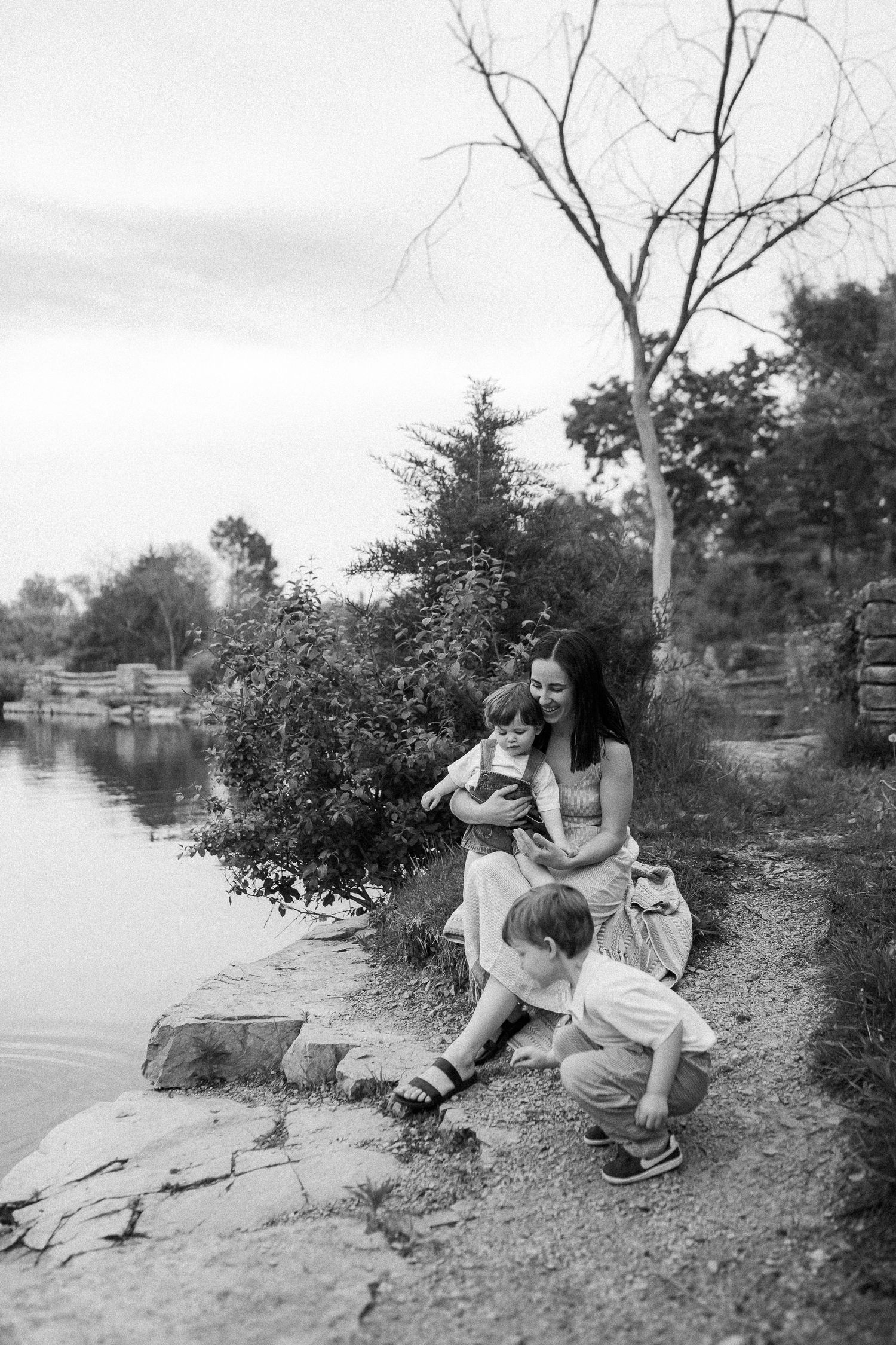 Peaceful black and white scene by a lake with reflections in the water.