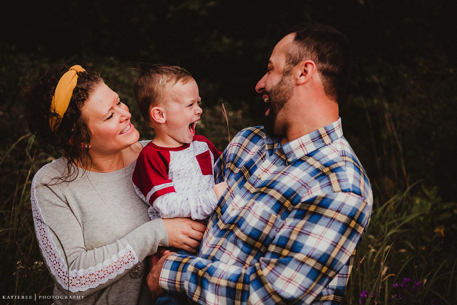 Family sharing joyful moment together outdoors in casual attire.