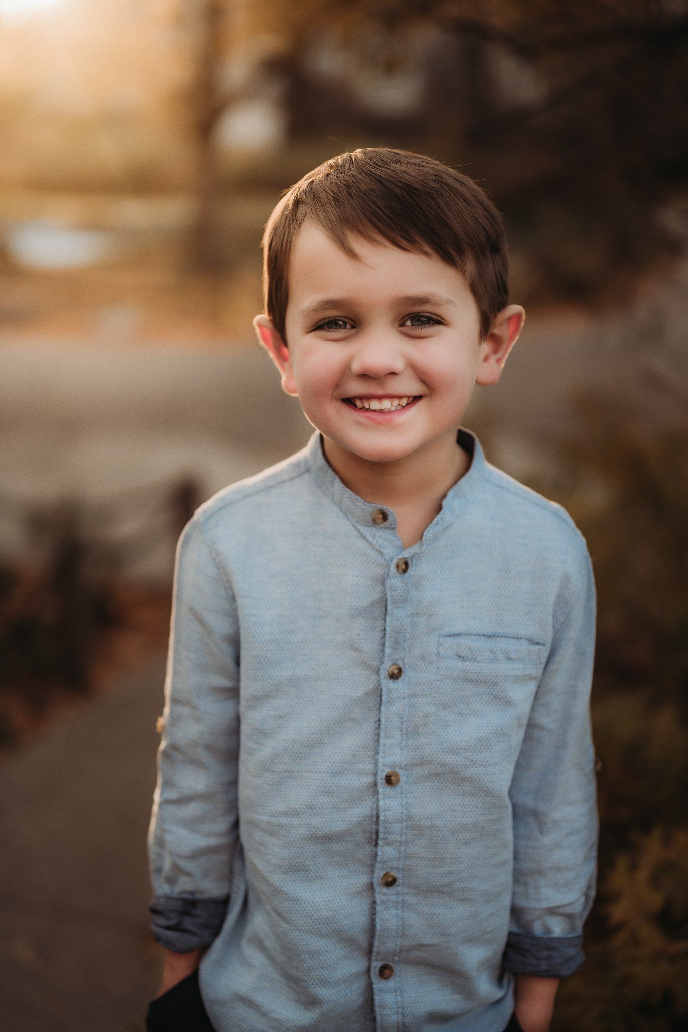 Close-up outdoor portrait with genuine smile in soft evening light.