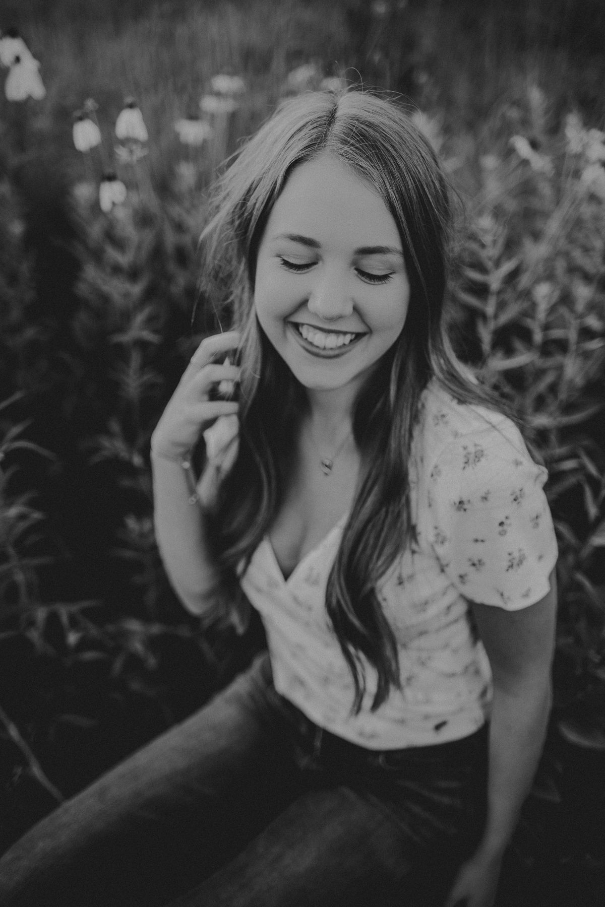 Black and white candid portrait showing genuine joy among wild plants.