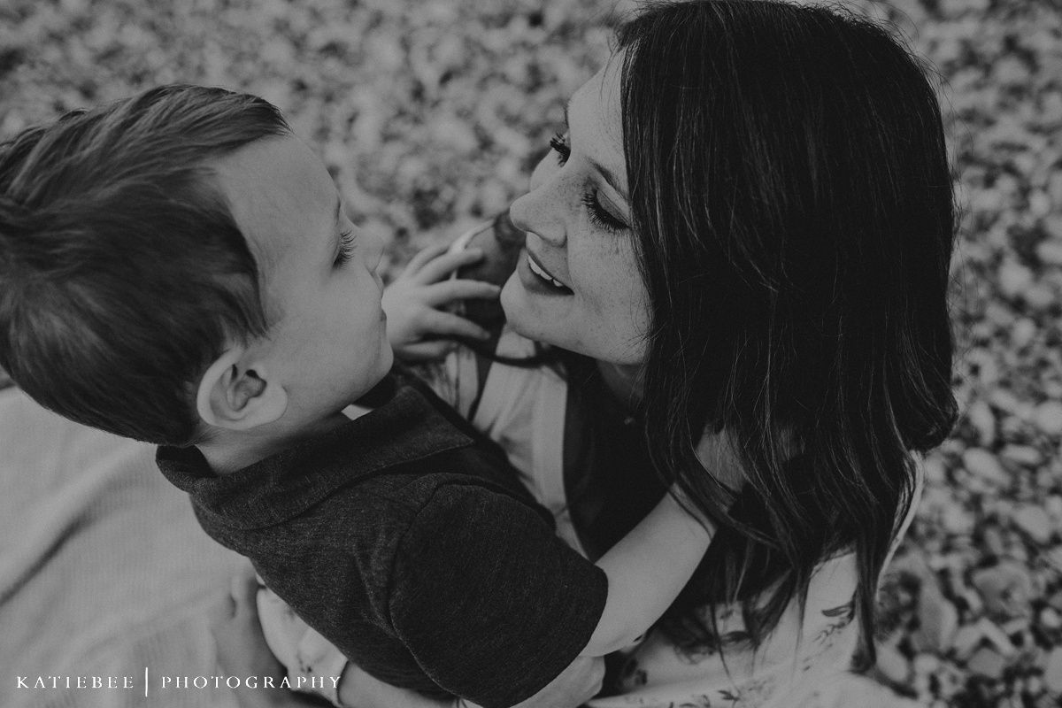 A black and white intimate portrait showing playful interaction and genuine emotion.