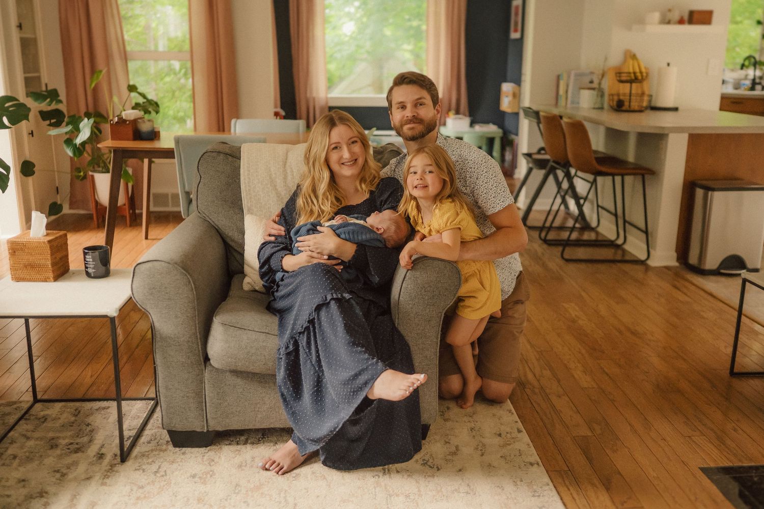 Natural light illuminates family moments in modern living room with hardwood floors.