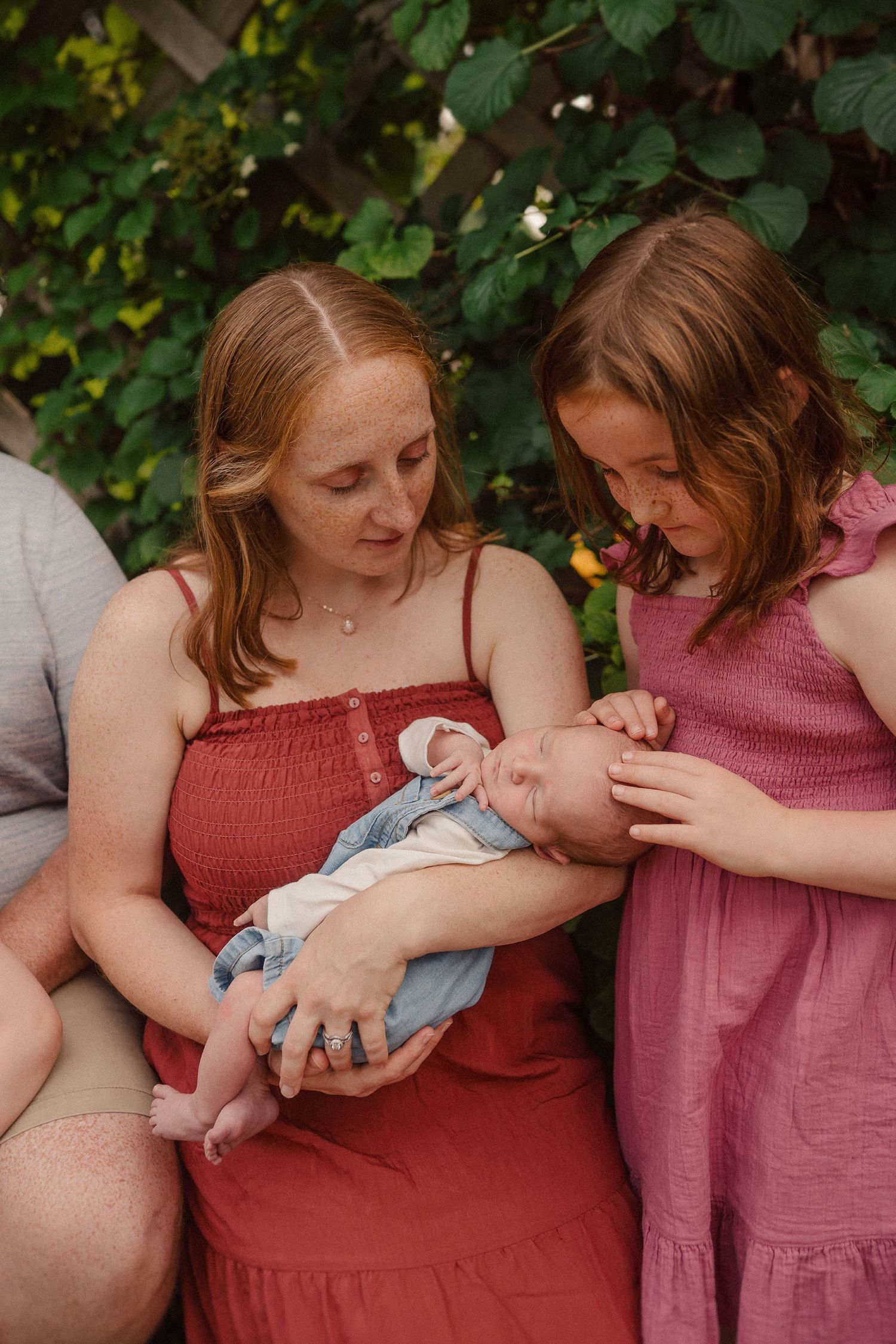 Sweet family moments shared between loved ones in a garden setting, dressed in warm shades of pink and red.