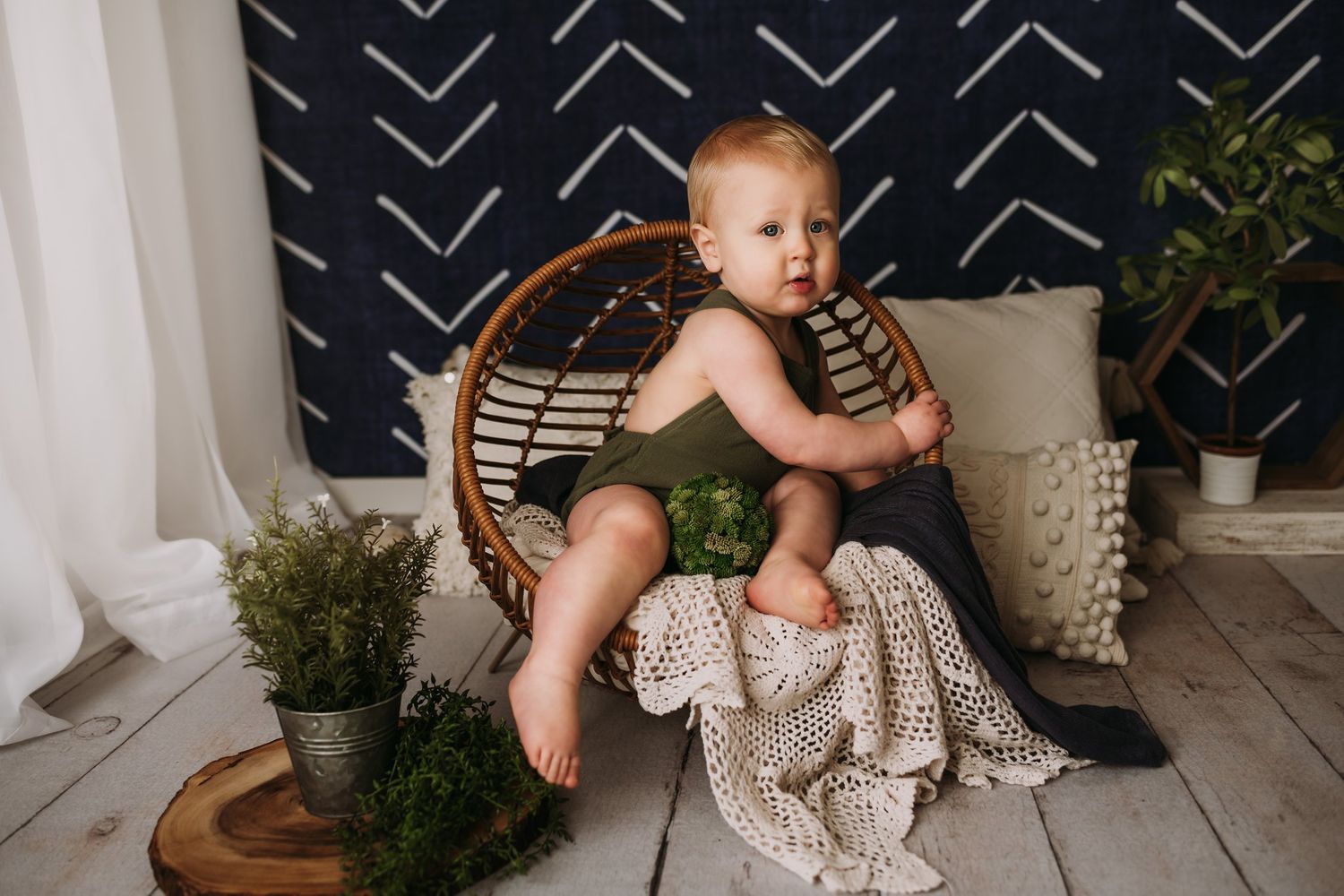 A decorative scene with a rattan chair and textured blanket against a navy chevron patterned backdrop.