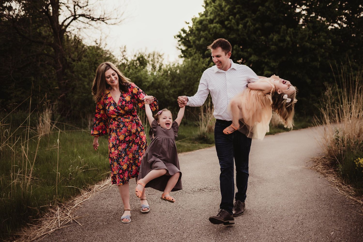 A playful family moment captured while walking on a path during golden hour.