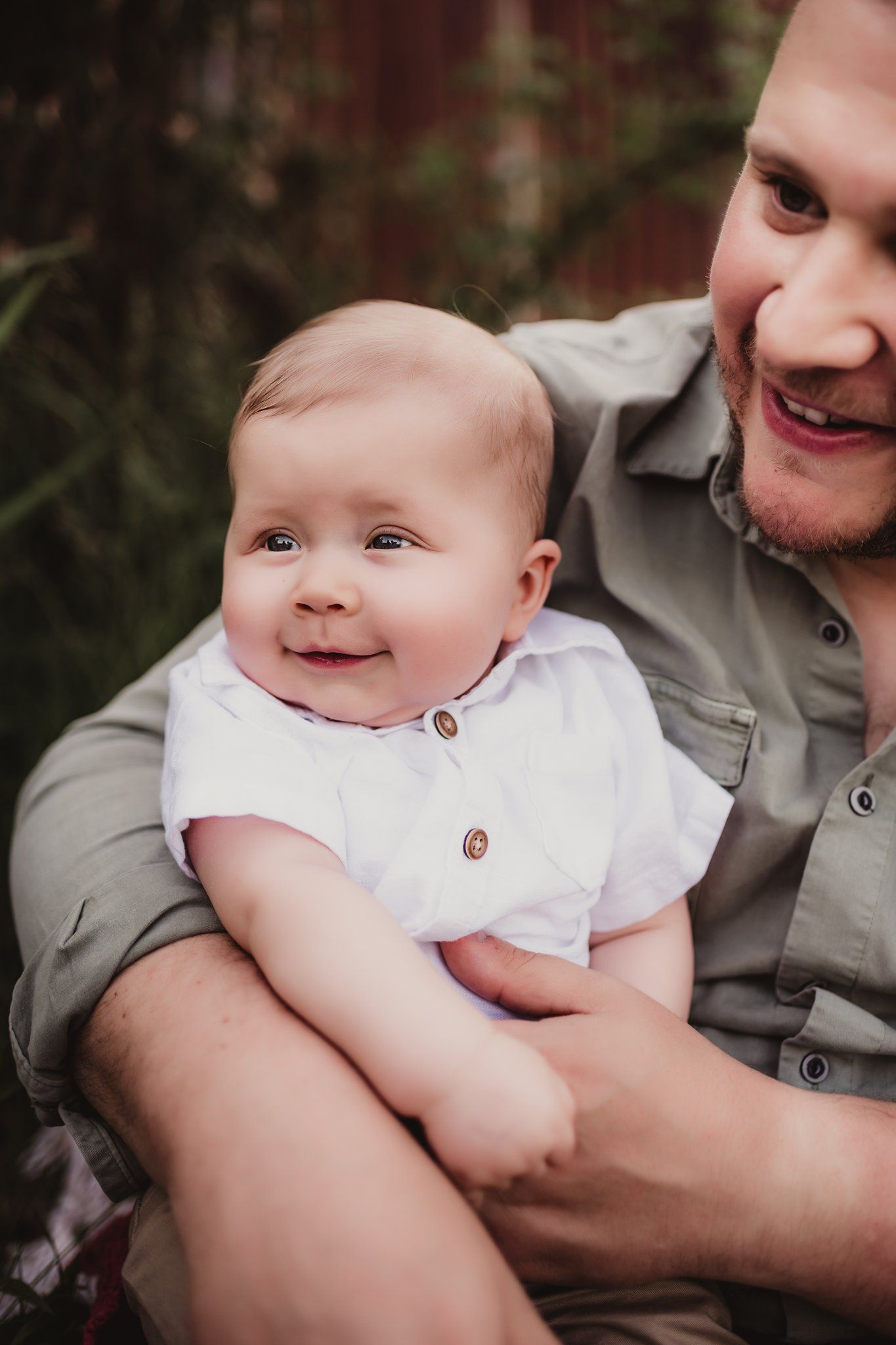 A joyful close-up portrait showing warm connection between child and parent outdoors.