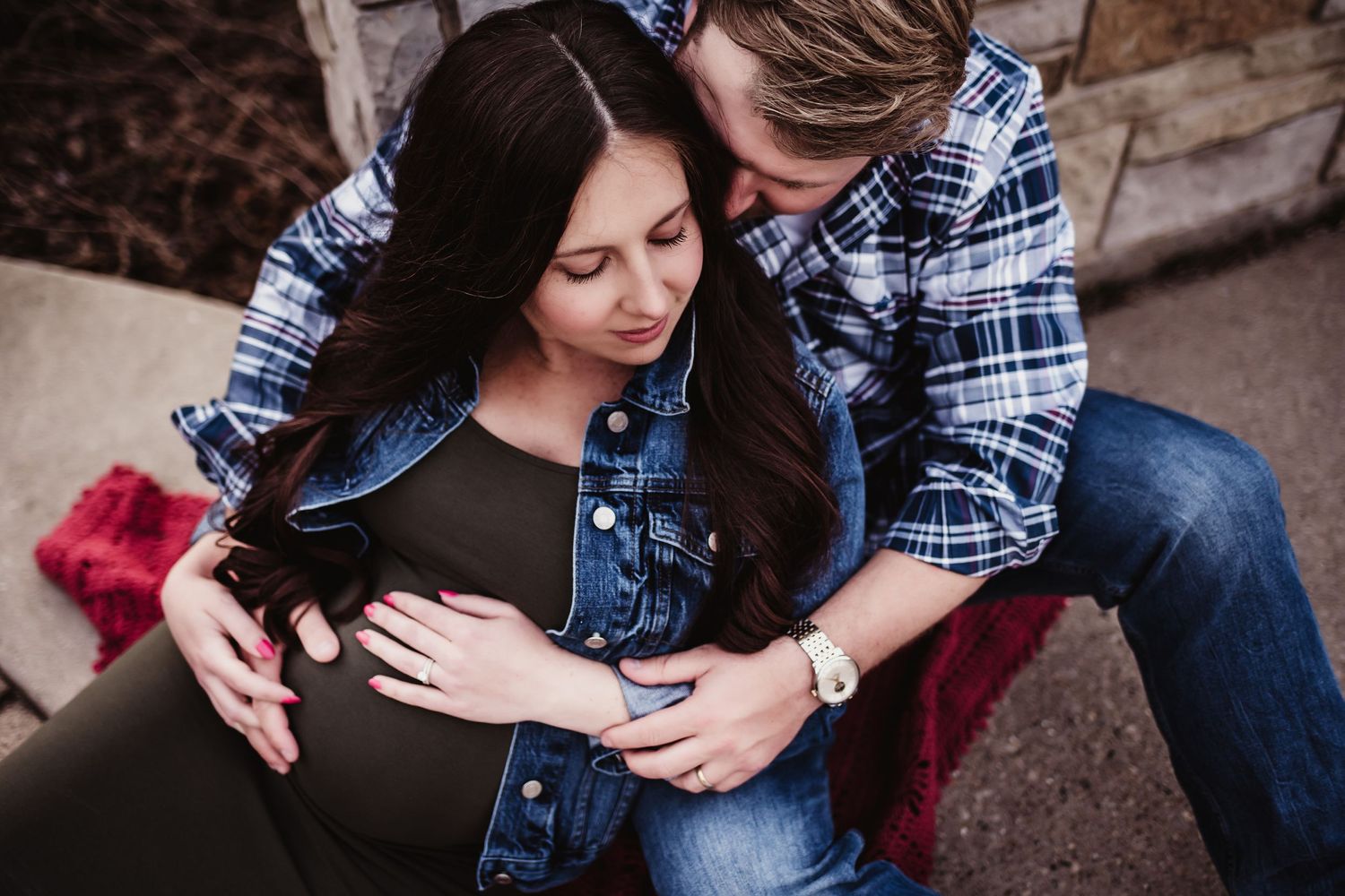 Intimate maternity photo with couple in casual wear showing affection.