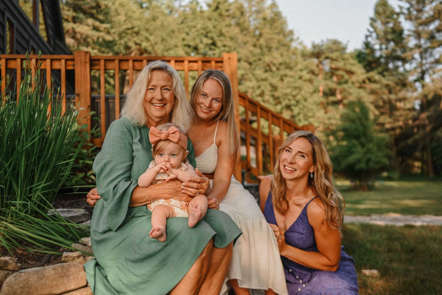 A warm sunset gathering on stone steps outside a modern cabin with wooden deck.