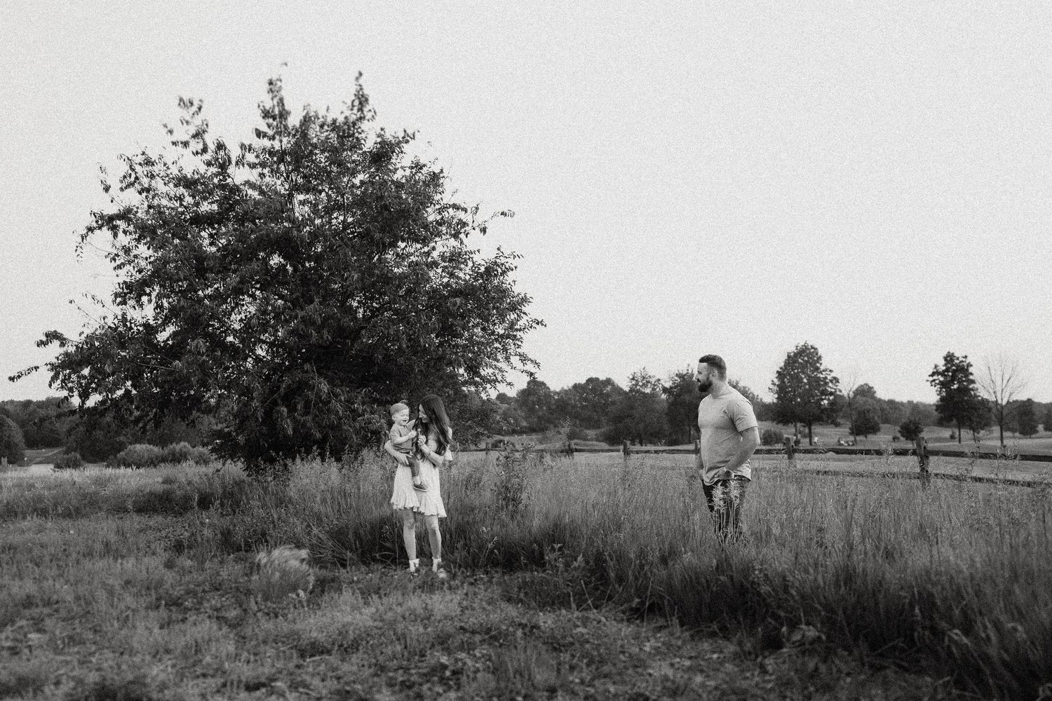 A black and white photo of a family enjoying time together in a rural field.