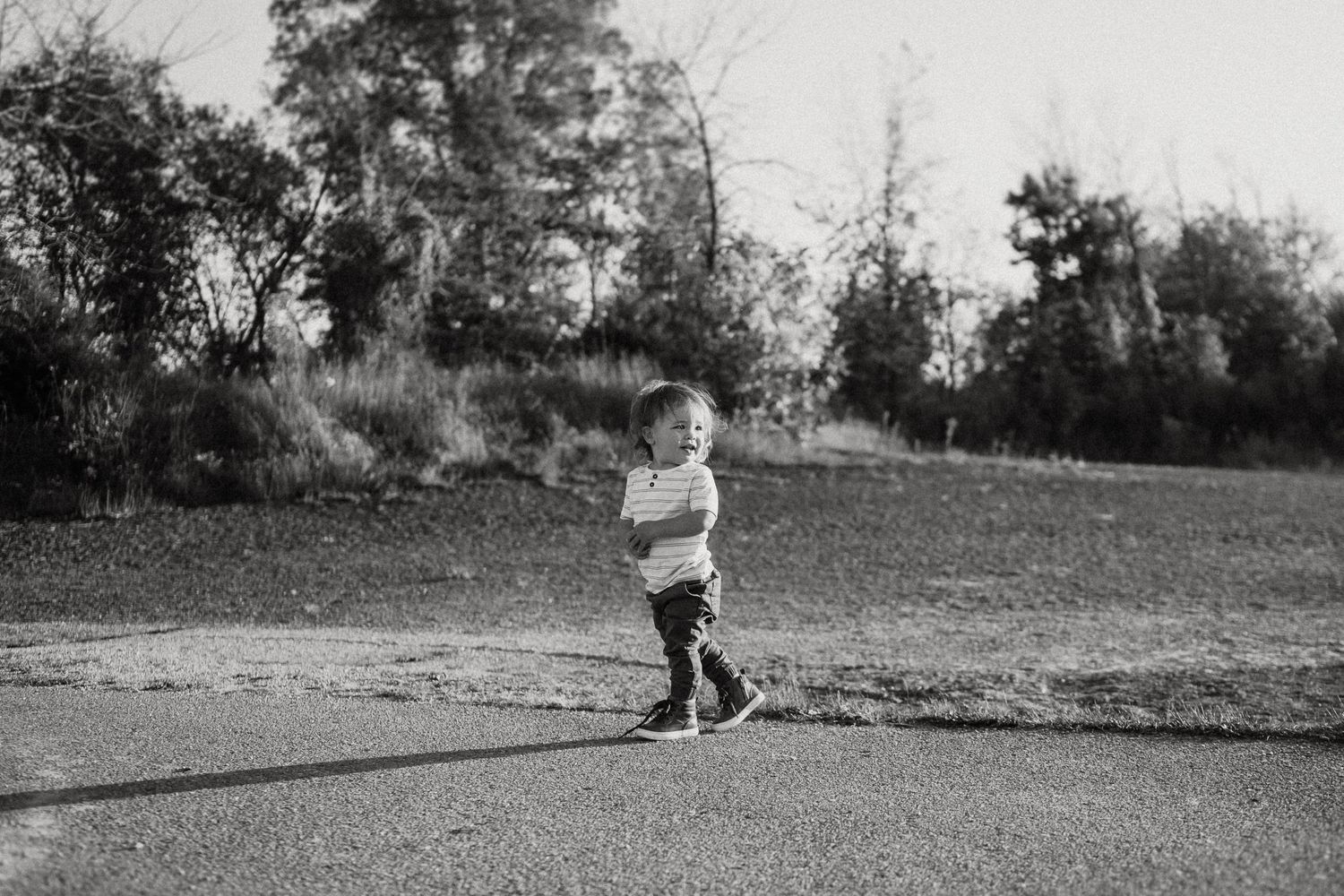 A child walks alone on a path in black and white photography.