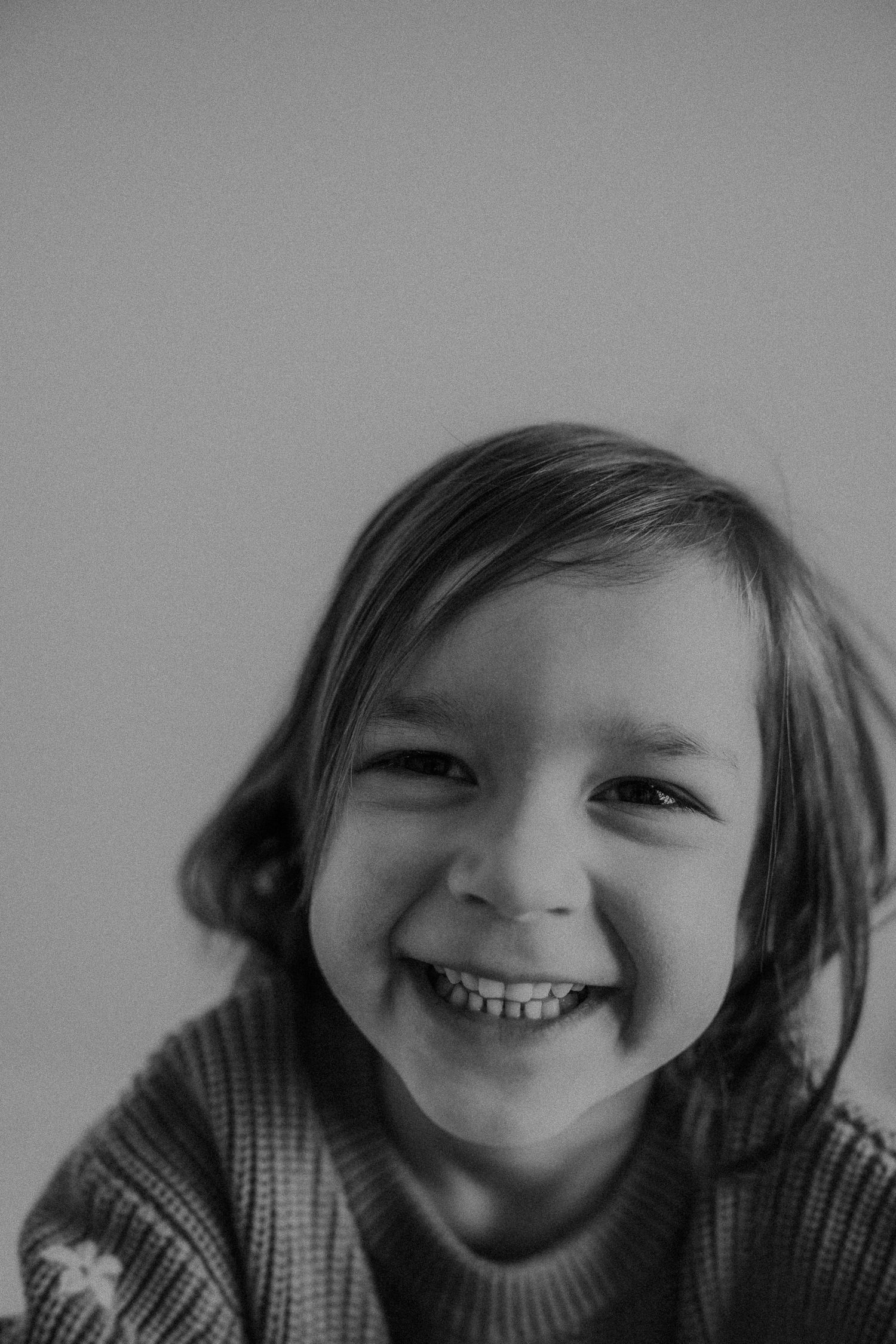 Candid black and white headshot capturing pure joy and laughter.