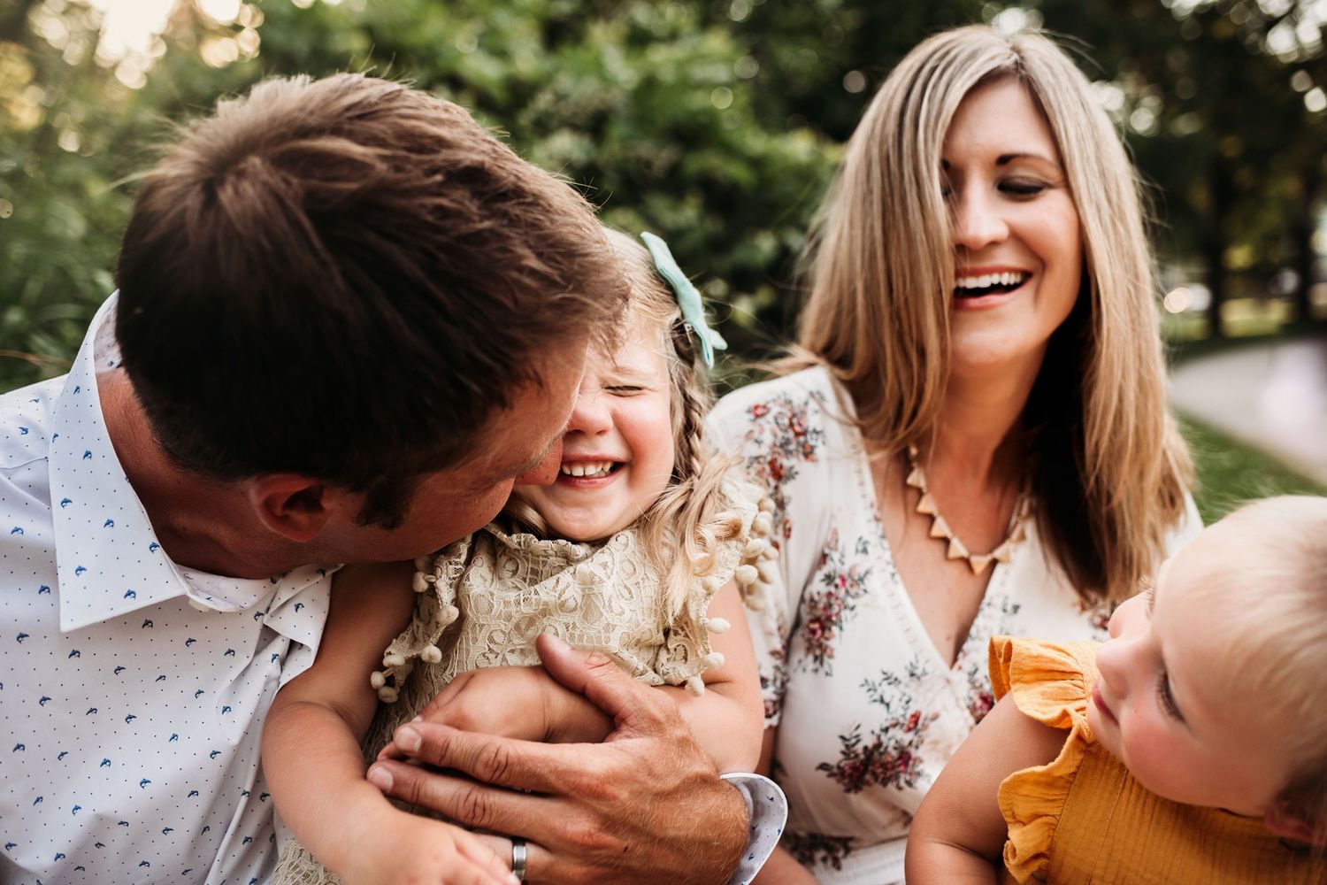 A joyful family moment captured outdoors with natural lighting and genuine laughter.