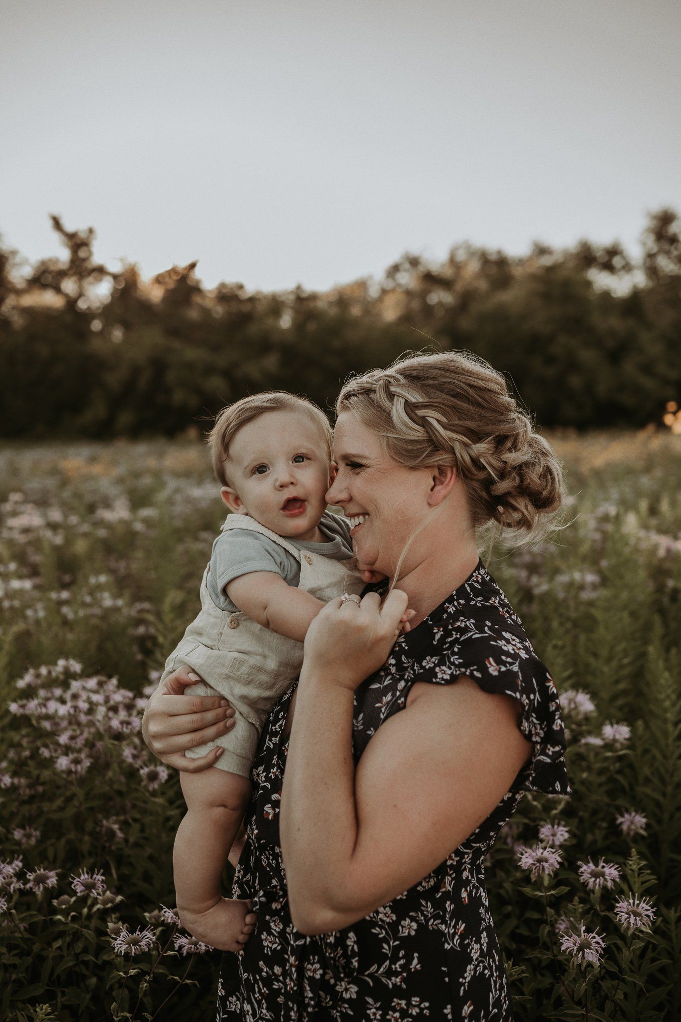 Joyful moment shared between two people in flowering meadow at sunset.