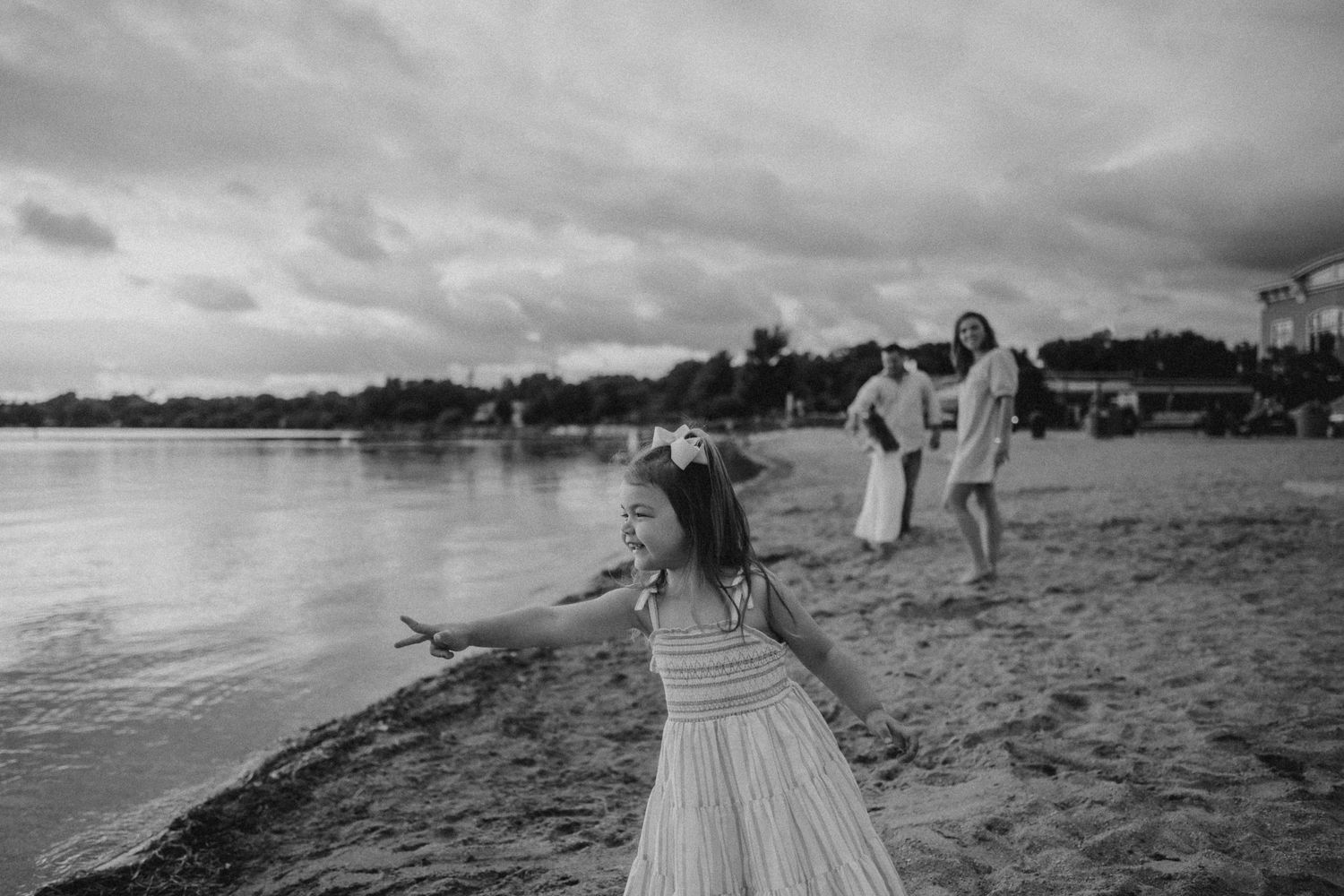 Black and white beach scene with people enjoying a moment by the water.