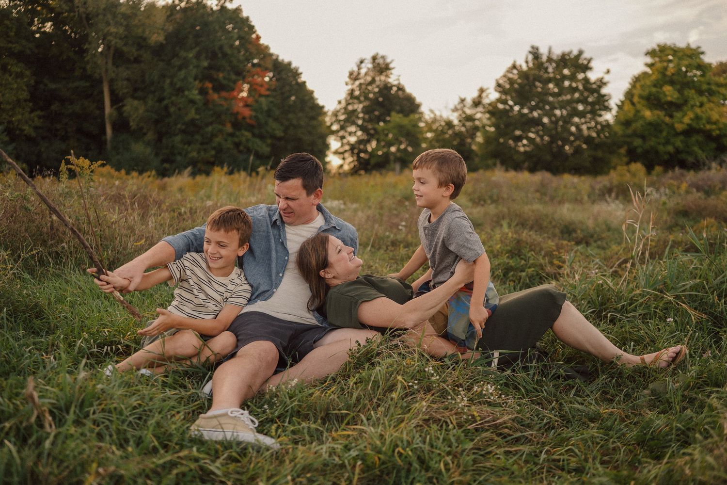 A joyful black and white family photo of people playing together in a field.