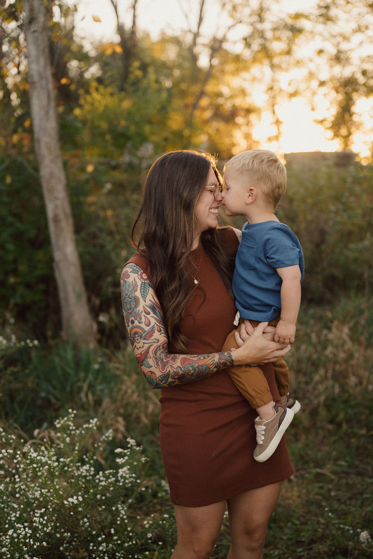 Mother and child sharing an affectionate moment outdoors during golden hour.