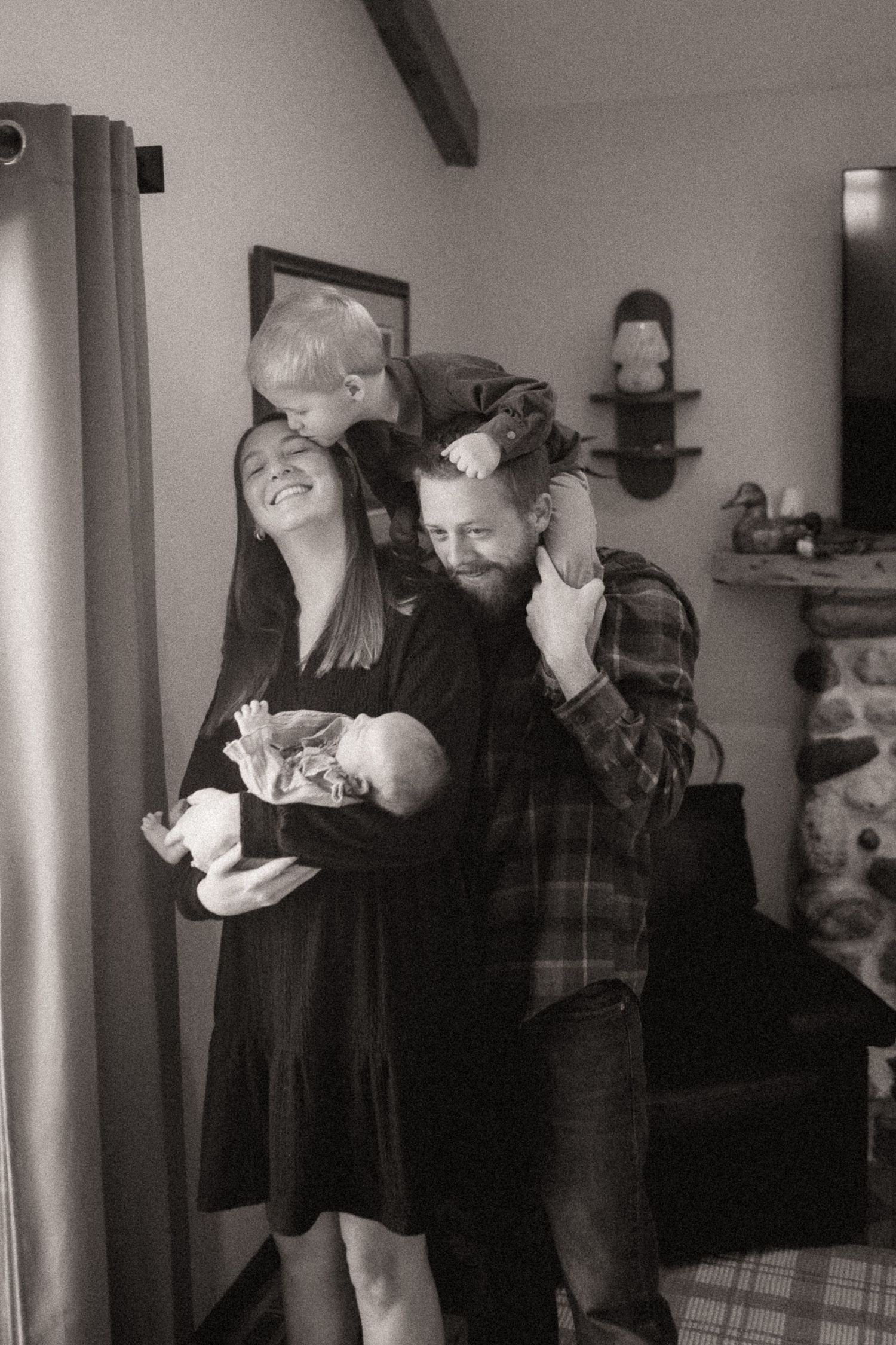 A series of intimate black and white photos showing tender moments between a couple in an indoor setting.