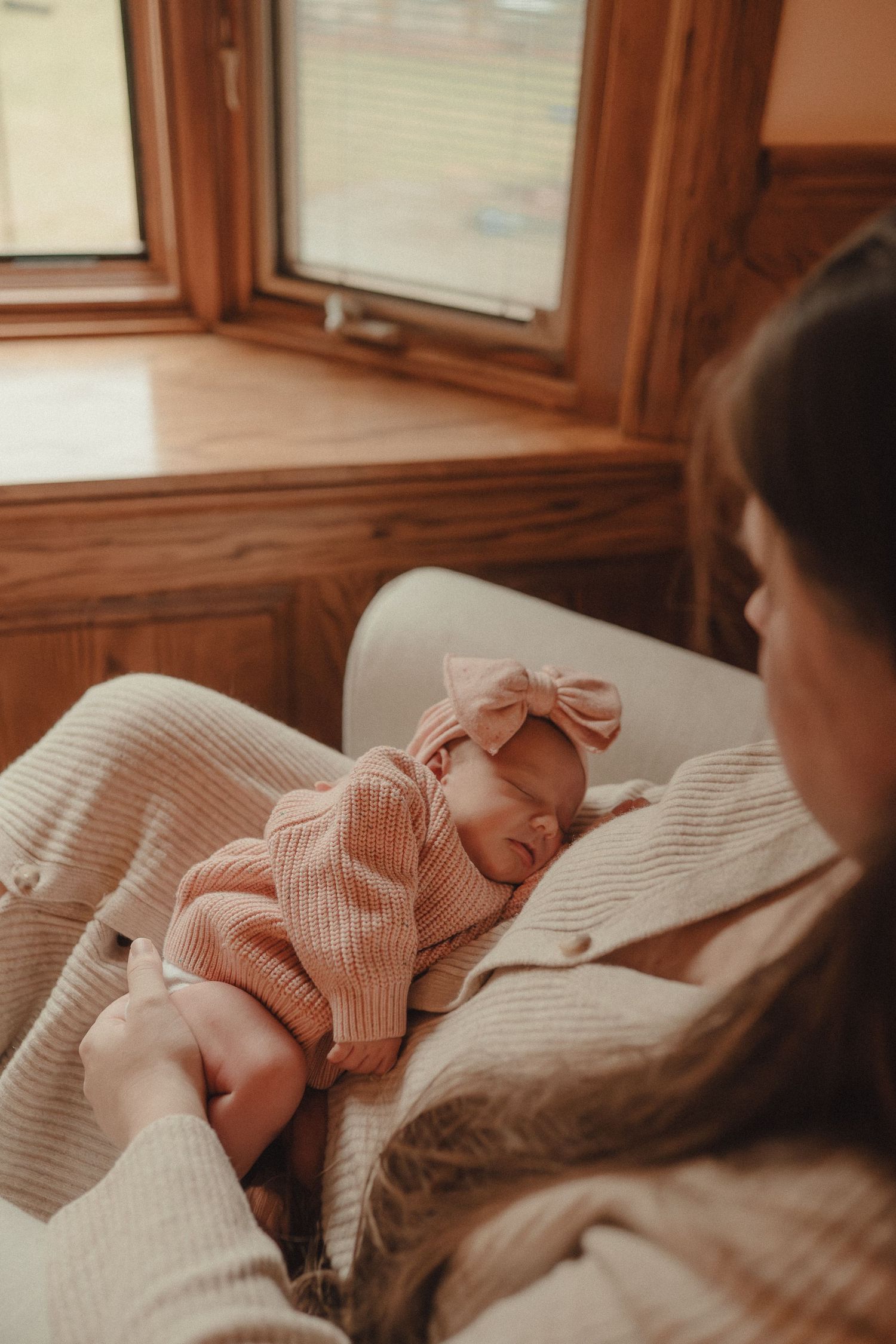 A peaceful moment captured of a baby resting on soft bedding in warm natural light.