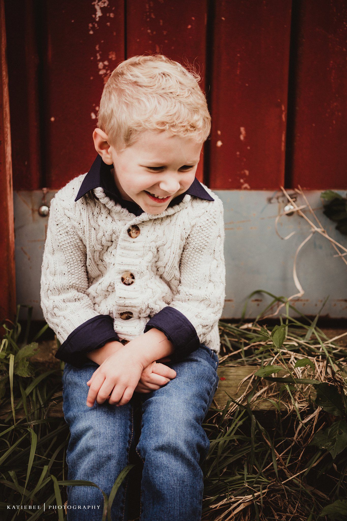 A joyful moment captured against a weathered red barn wall.