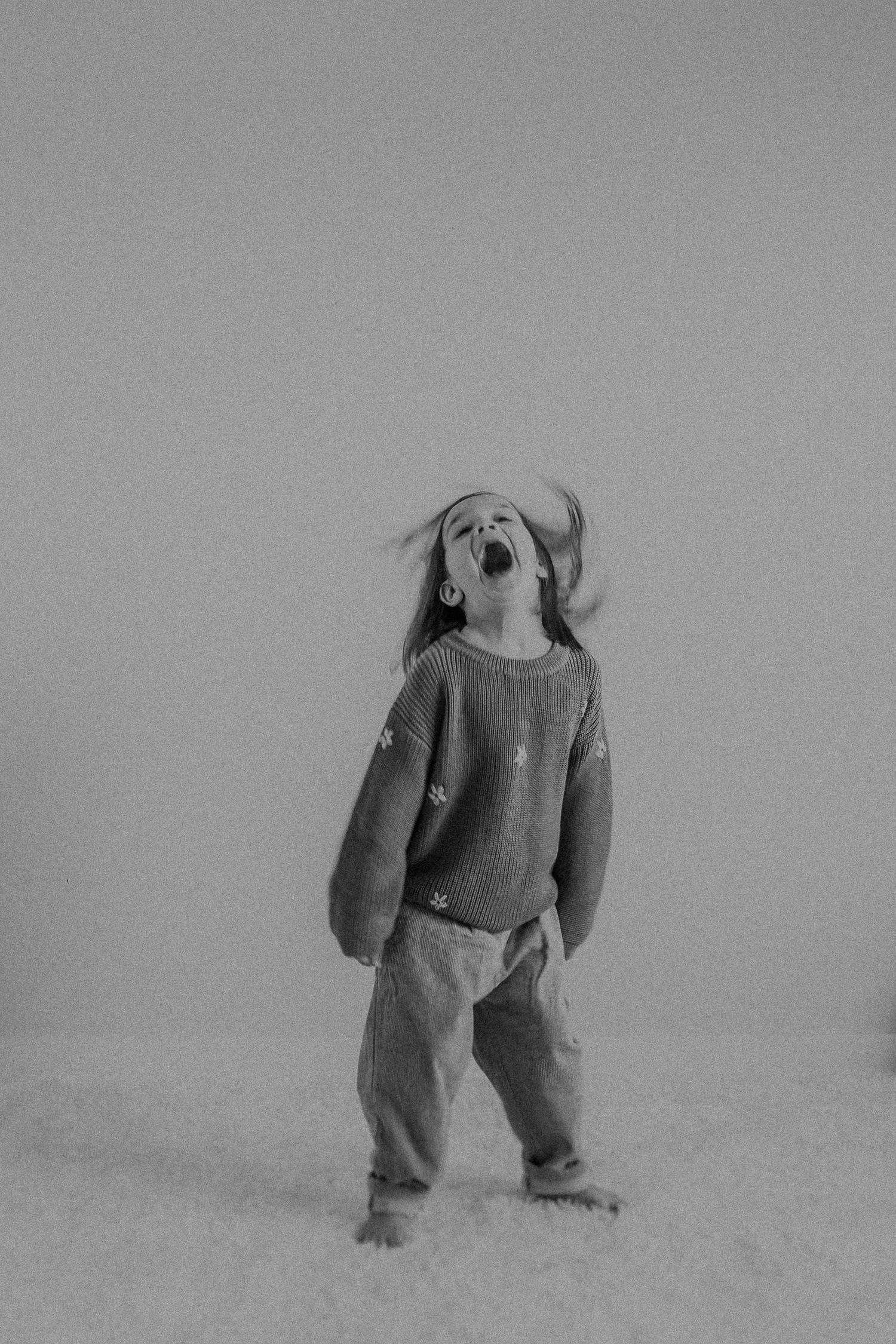 Dynamic black and white portrait capturing enthusiastic movement and pure joy.
