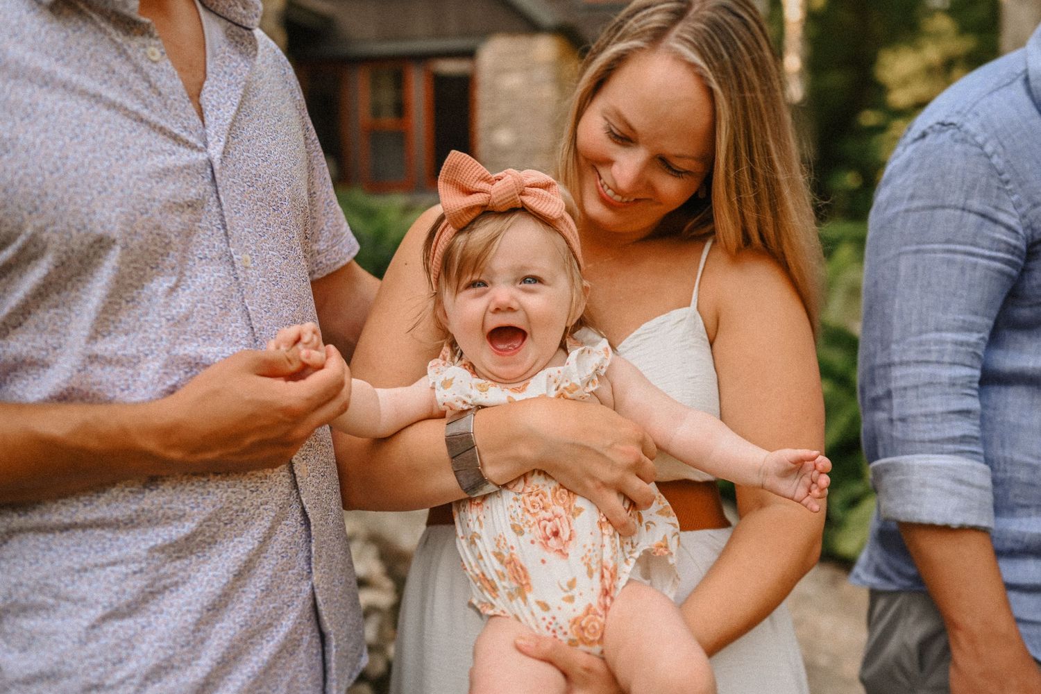 A joyful moment shared between three people outdoors on a sunny day.