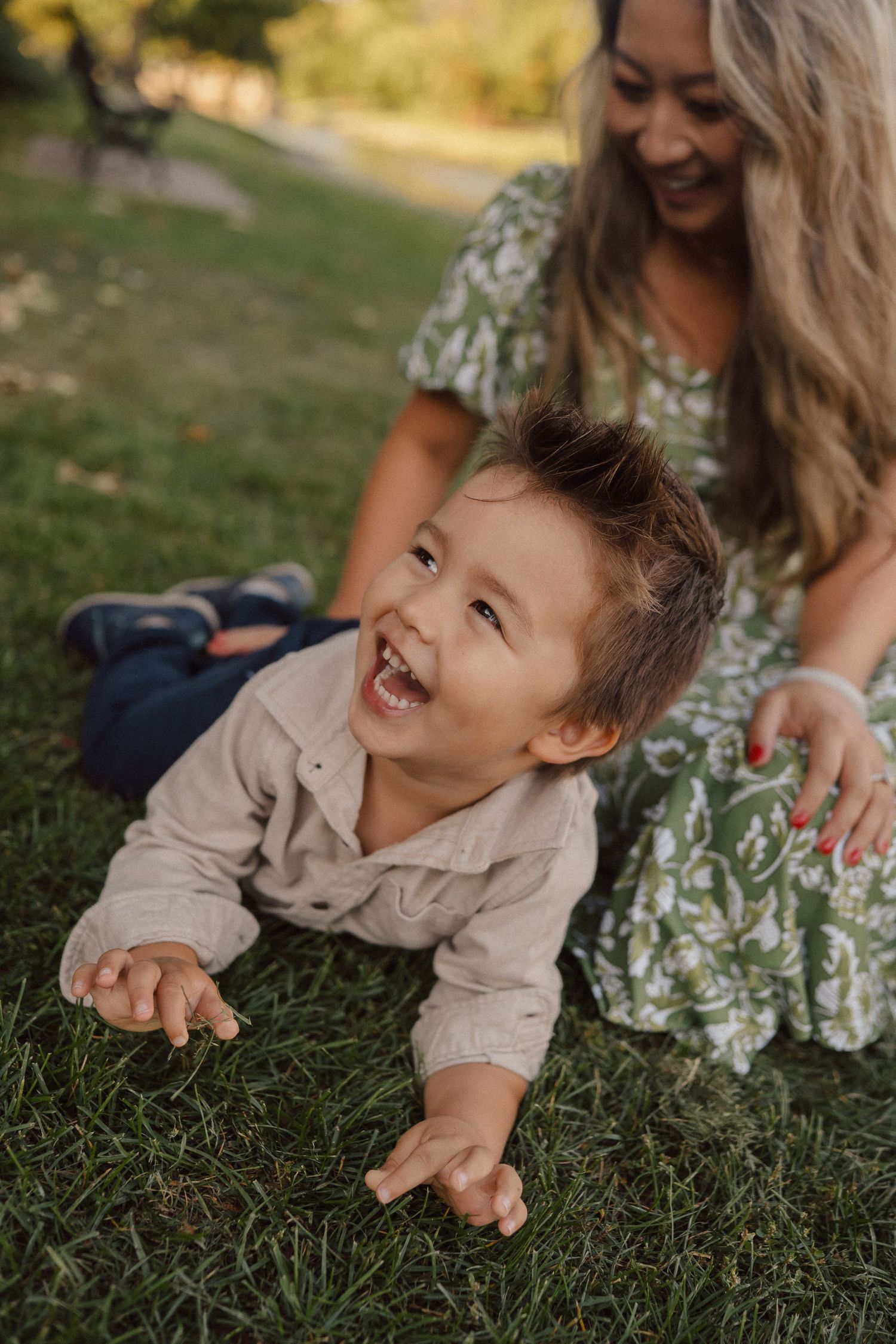 Joyful moments captured on a grassy hill during a warm evening photoshoot in a park setting.