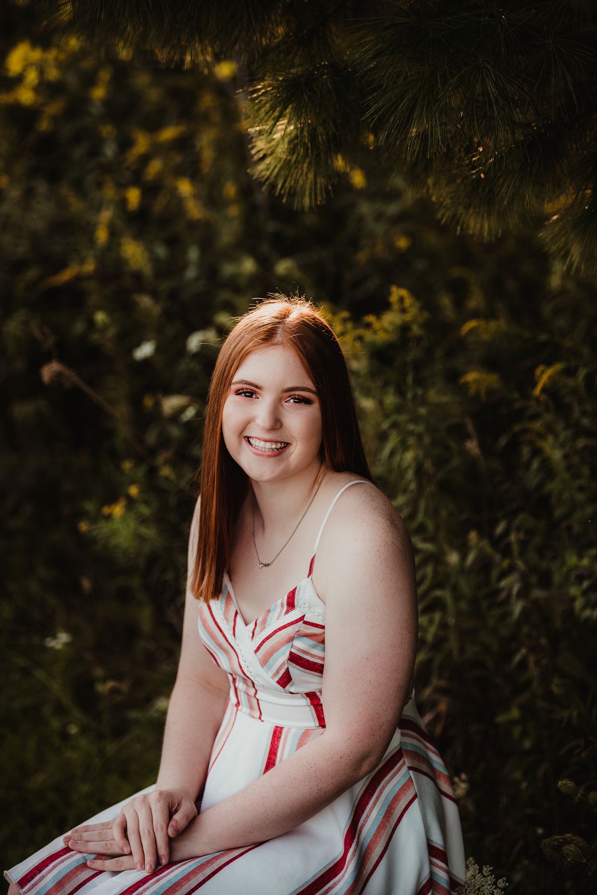 A portrait session in nature featuring a summer dress against a backdrop of yellow wildflowers and foliage.