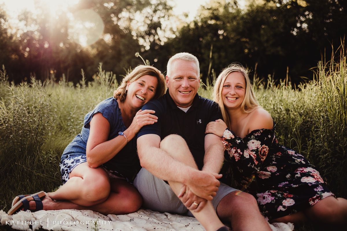 Group photo session in field during golden hour with natural backdrop.
