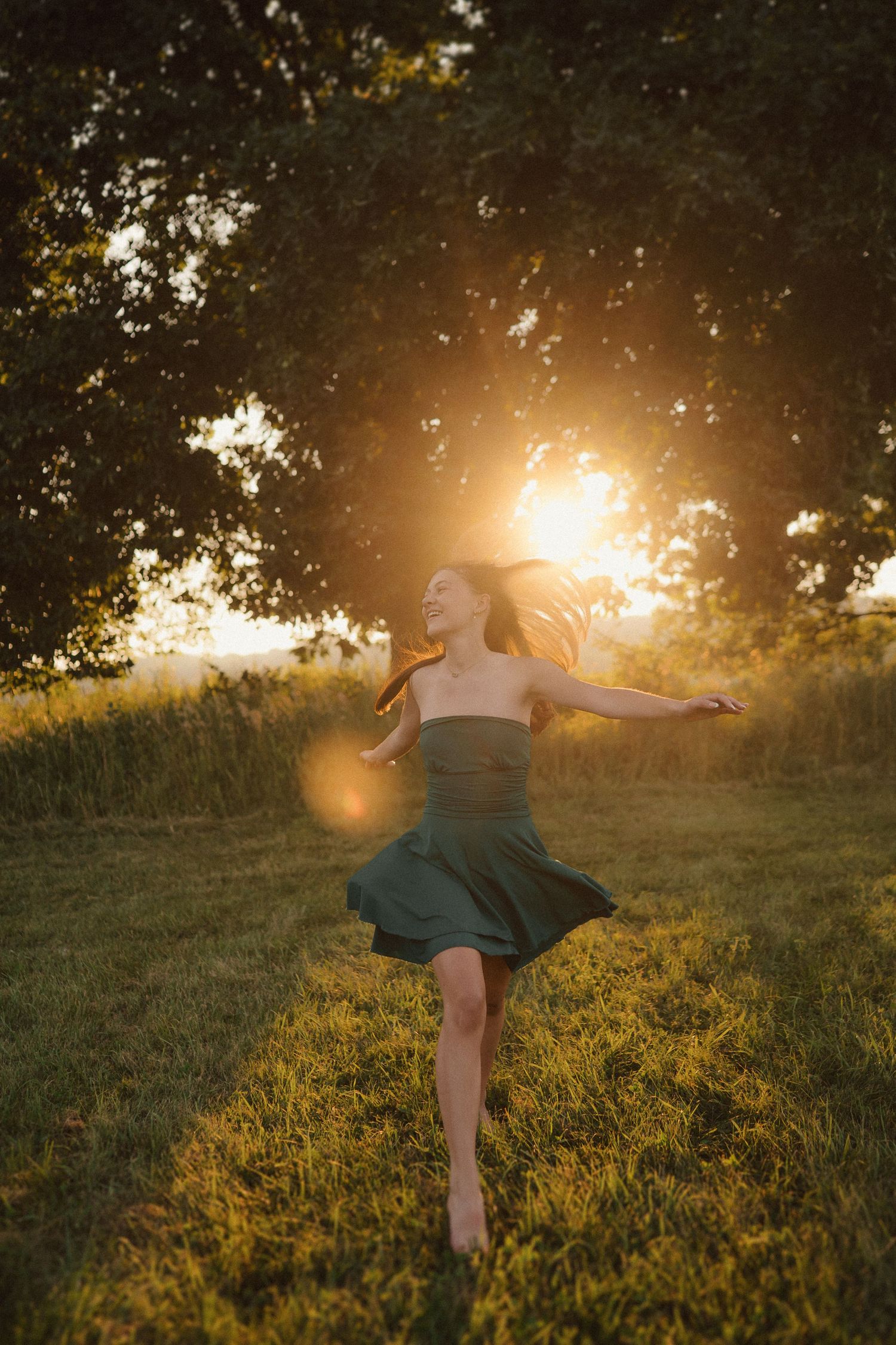 Figure in a flowing dress twirls in a golden meadow at sunset creating a dreamy summer scene.