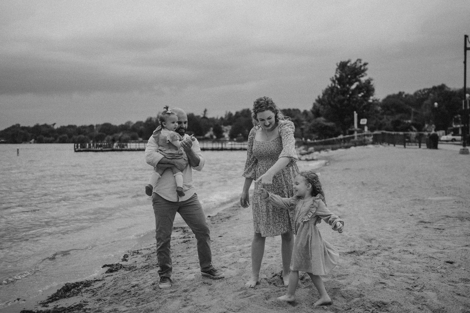 A black and white capture of a playful family moment at the beach.