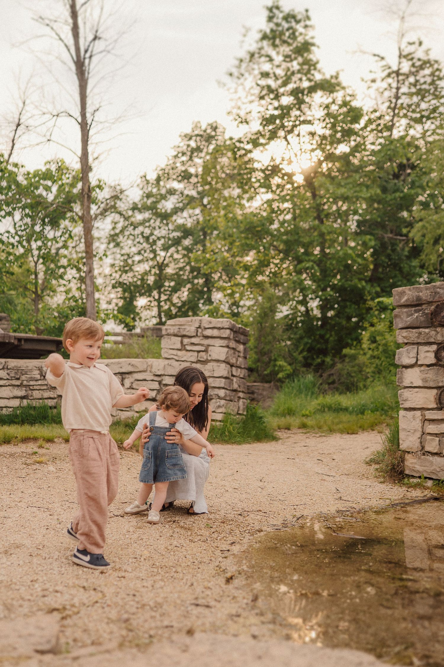 A series of candid photos of children playing near stone pillars during a sunset golden hour session.