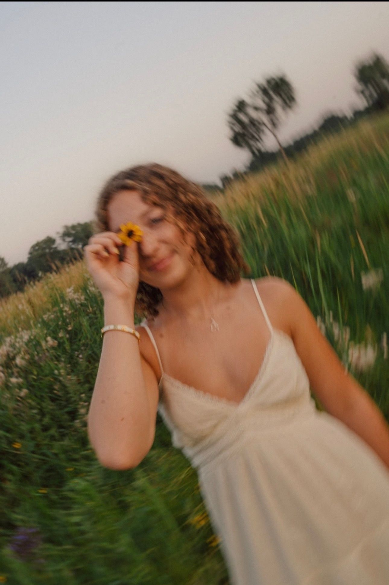 A dreamy motion-blur portrait in a wildflower field at golden hour.